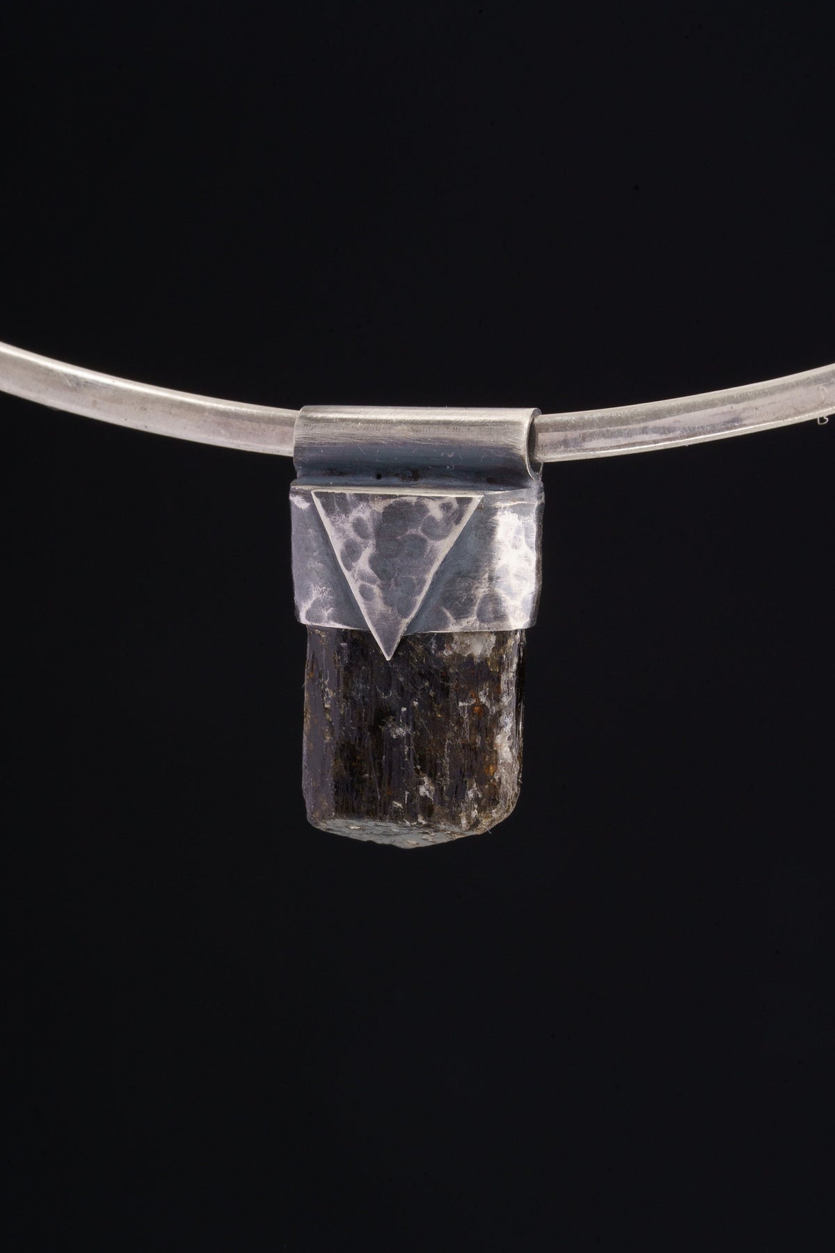 Himalayan Dravite Tourmaline Stack Pendant shown on black background with oxidized sterling silver cap and dark terminated crystal.