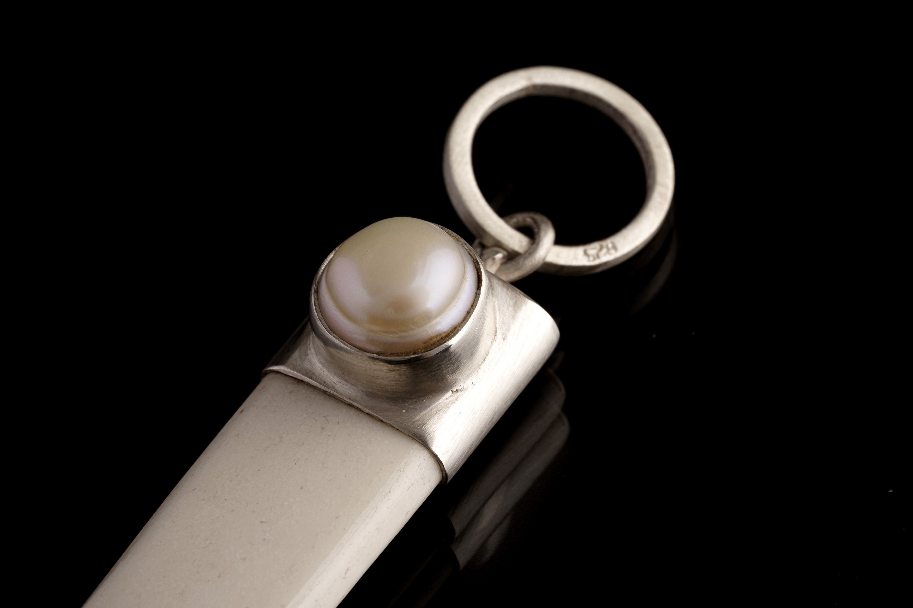 Close-up of South Sea Pearl pendant showing shiny brushed 925 sterling silver cap and luminous Pearl setting.