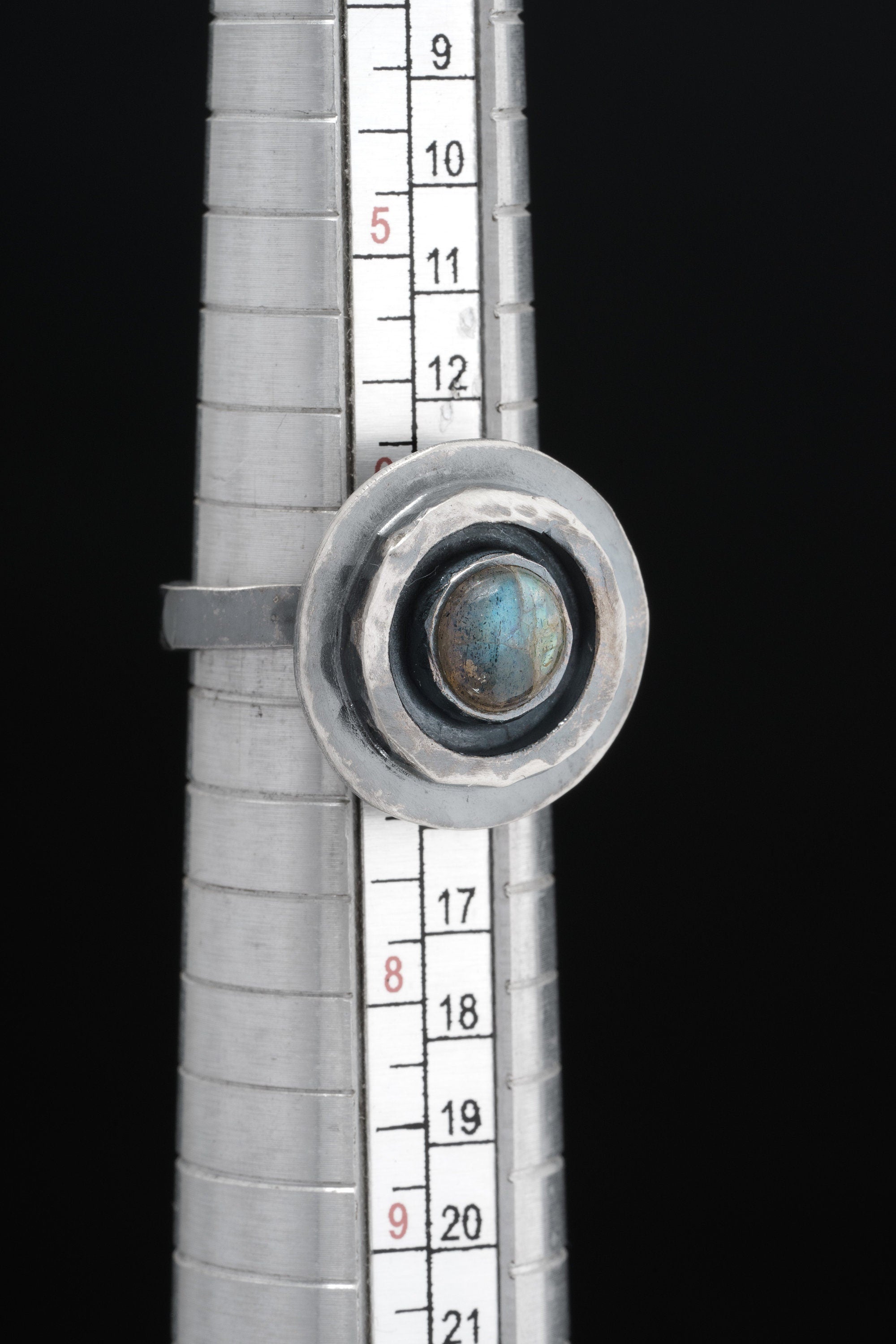 Old World Labradorite Adjustable Ring shown beside a ruler for scale with textured sterling silver and Labradorite centre.