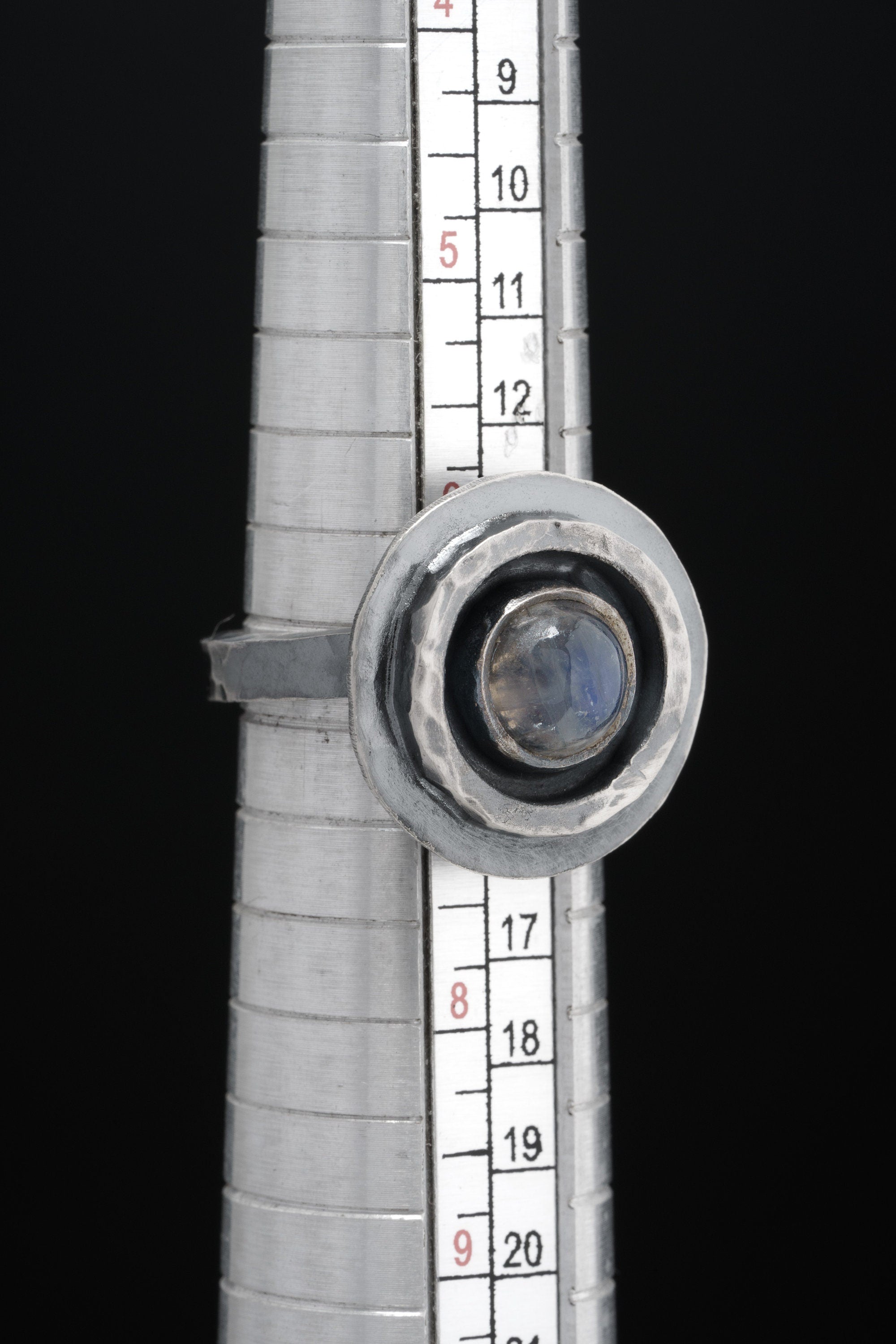Blue Moonstone Ring shown beside a ruler for scale with adjustable oxidized silver band and oval Moonstone.