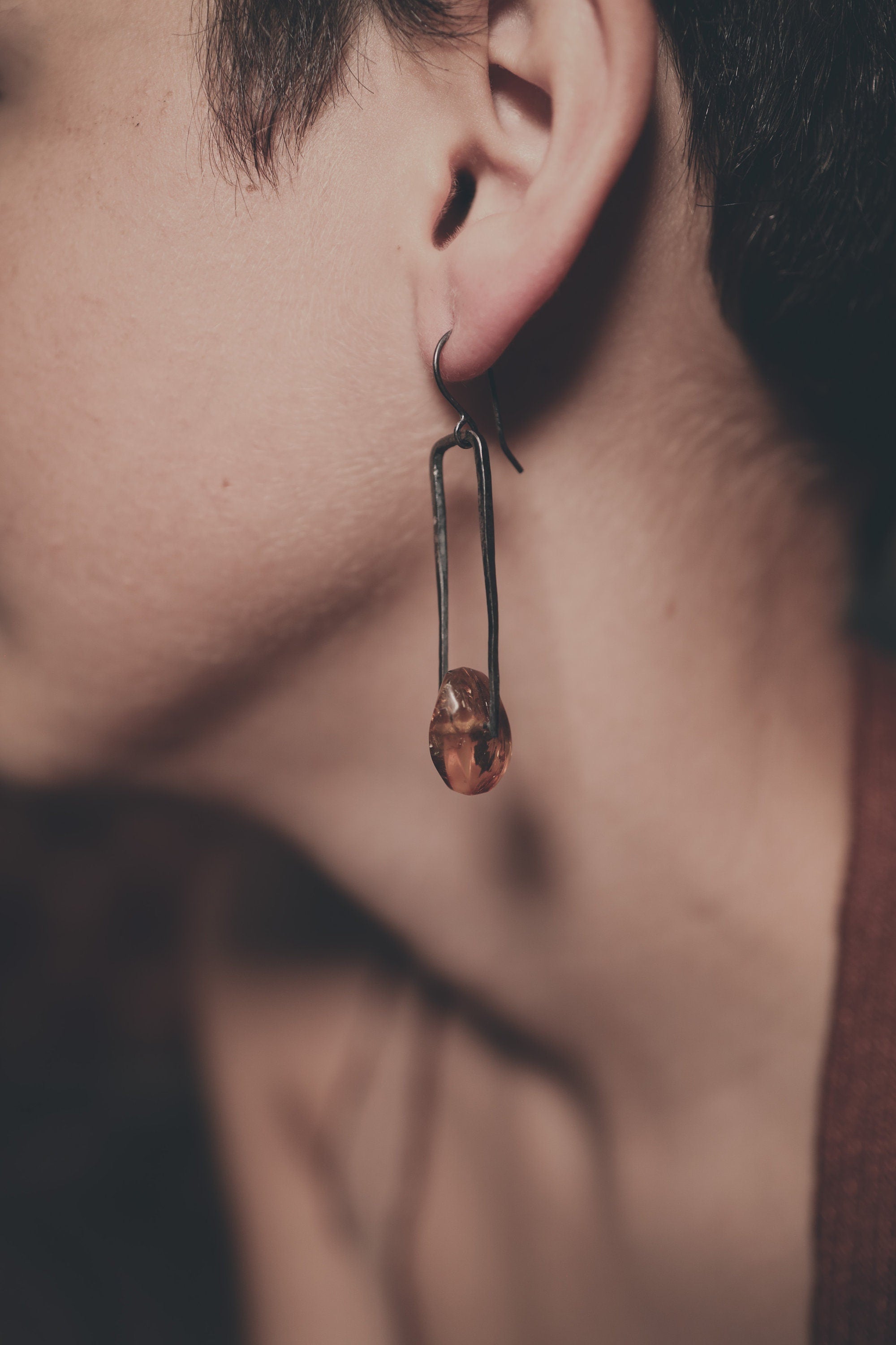 Rustic Amber statement earring shown worn on a model, with layered sterling silver and golden fossil resin detail.