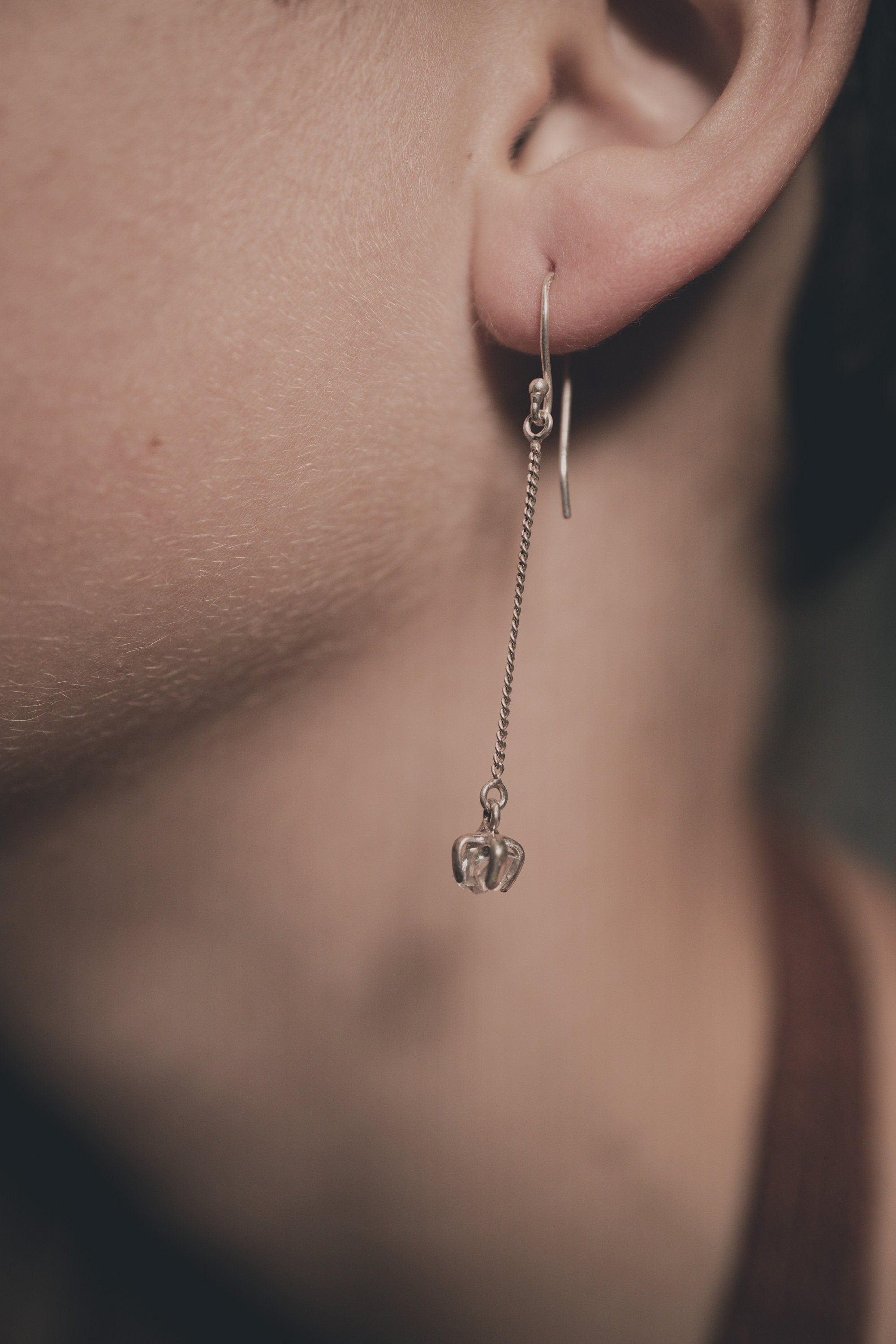 Herkimer Diamond Quartz dangle earrings shown worn on a model, with fine sterling silver hooks and small crystal drops.