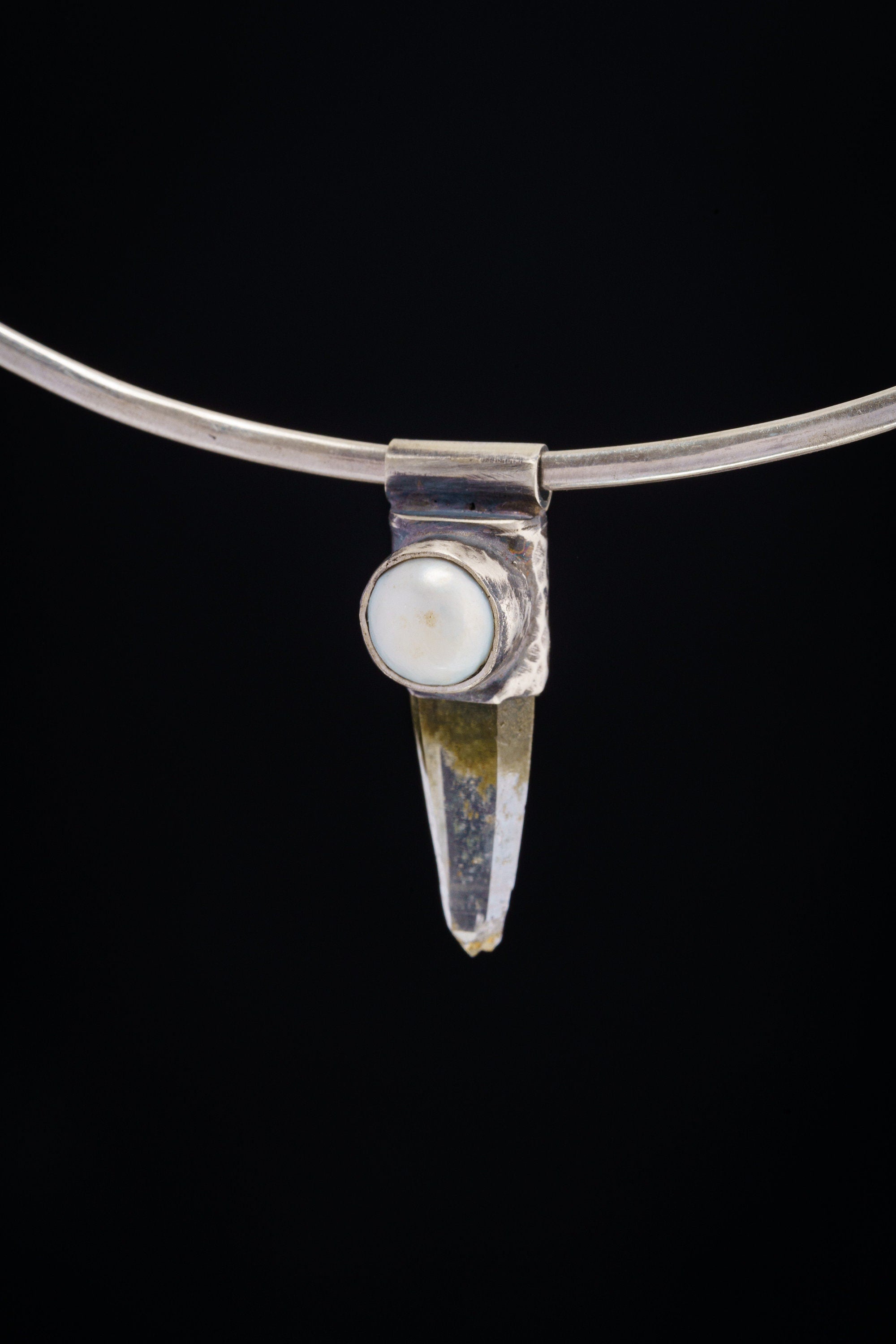 Nepal Quartz and South Sea Pearl Stack Pendant shown on black background with silver choker and pointed crystal body.