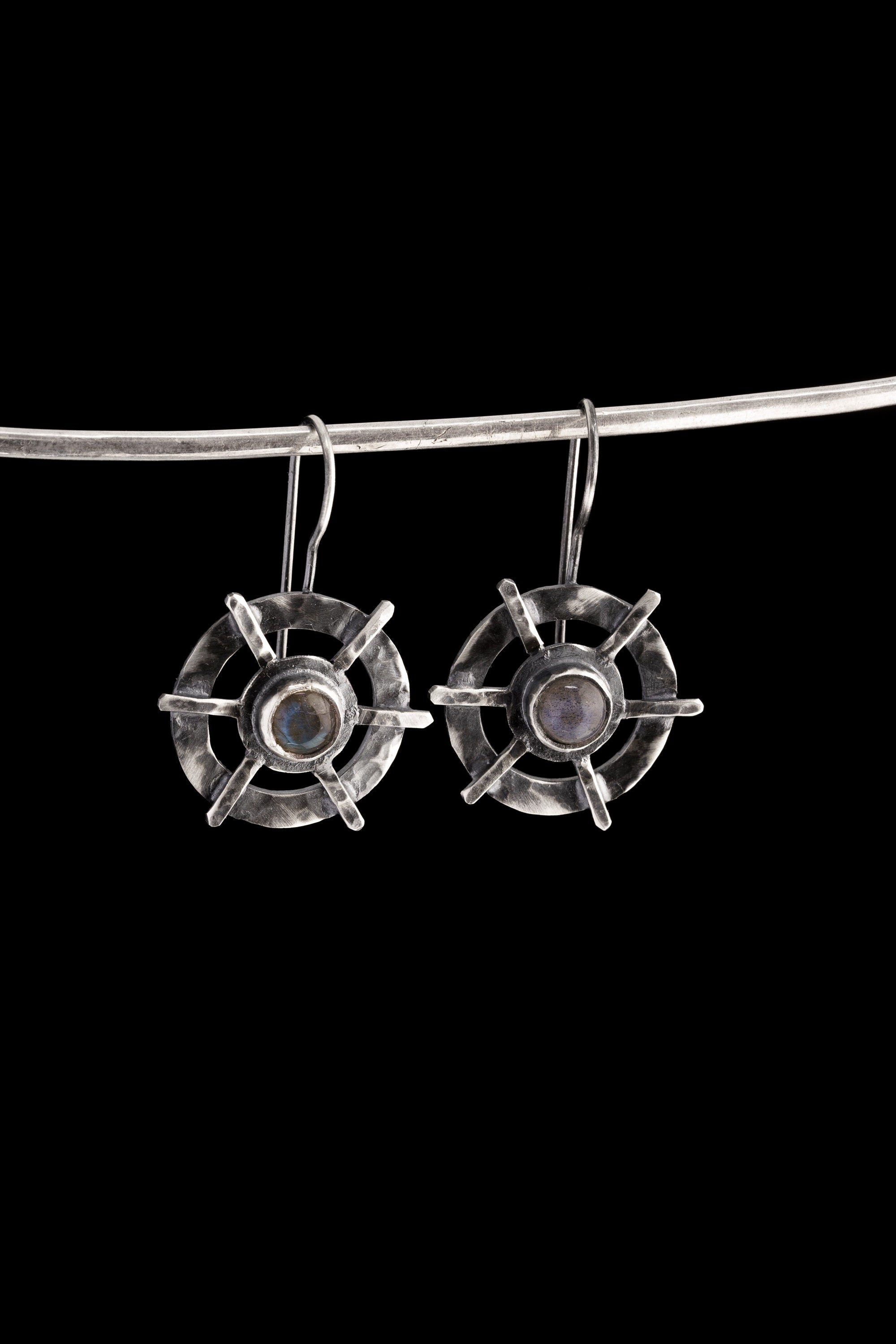 Labradorite earrings displayed on a dark background, showing circle cross construction and polished sterling silver finish.
