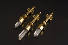 Standing Ganesha Clear Quartz talisman pendant shown on a dark background with polished brass figure and Himalayan Quartz crystal.