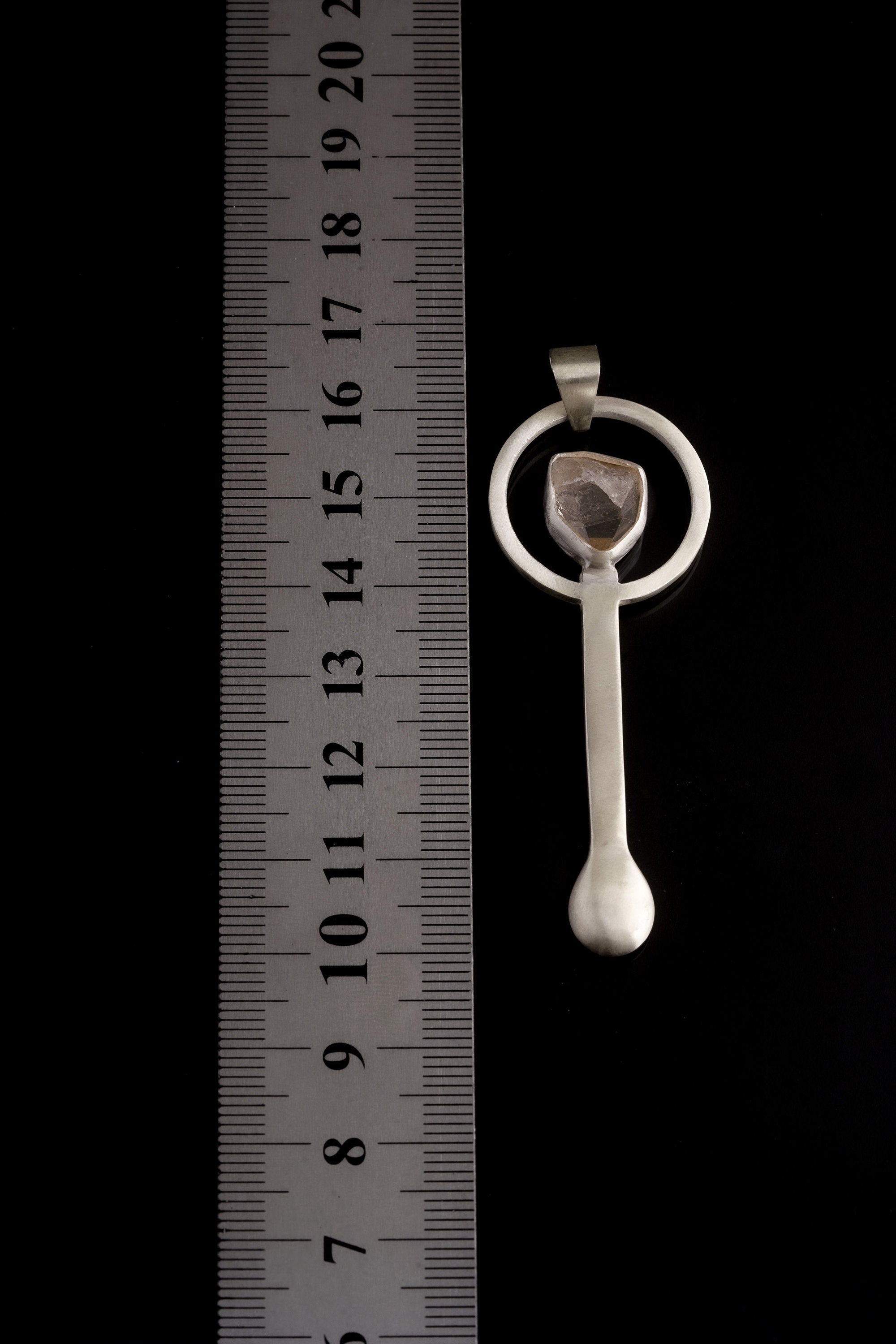 Clear Quartz sterling silver spoon pendant shown beside a ruler for scale with solid cast silver body.