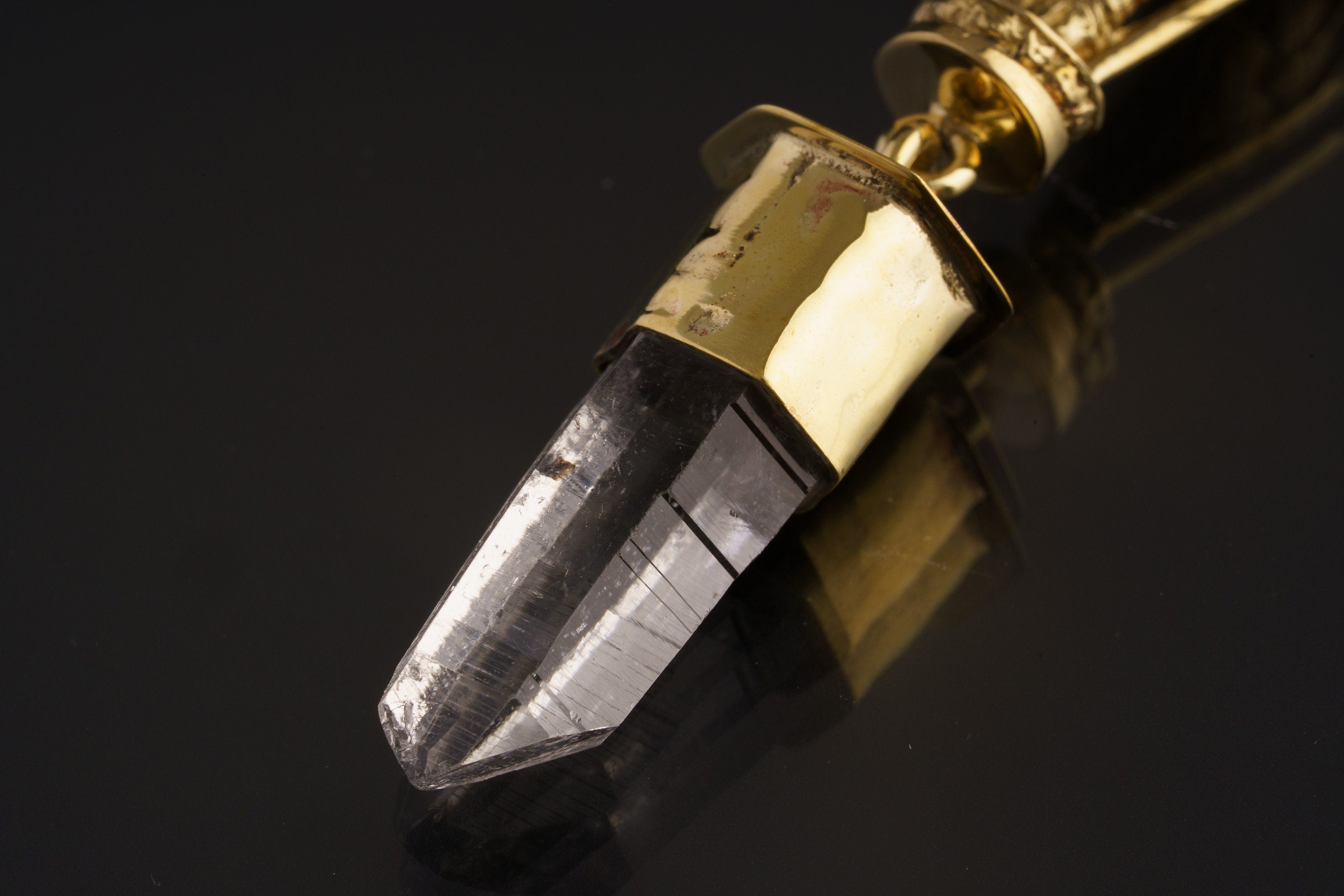 Close-up of Himalayan Clear Quartz crystal suspended beneath a hammered brass Lord Shiva pendant.
