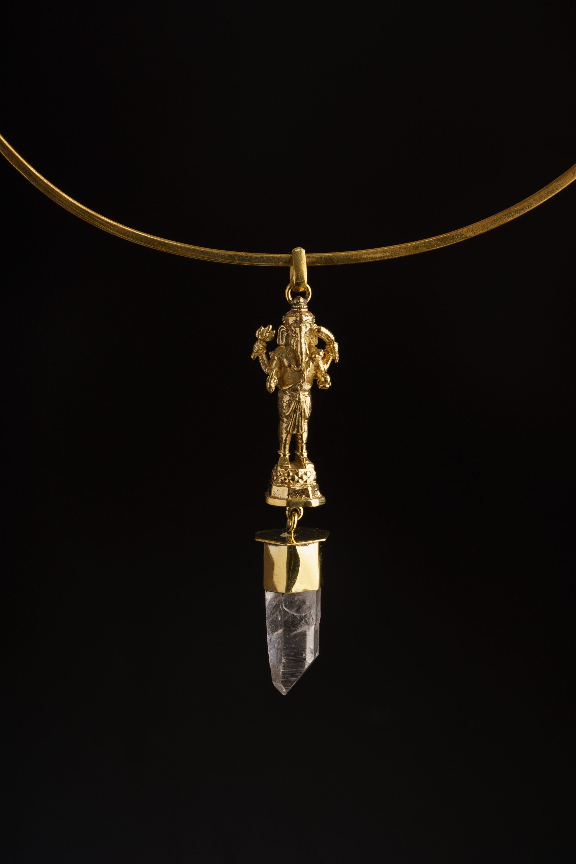 Standing Ganesha Clear Quartz pendant shown worn on a black background as a lightweight brass spiritual necklace.