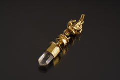 Dancing Ganesha Clear Quartz pendant shown on a dark background with warm brass setting and clear crystal point.