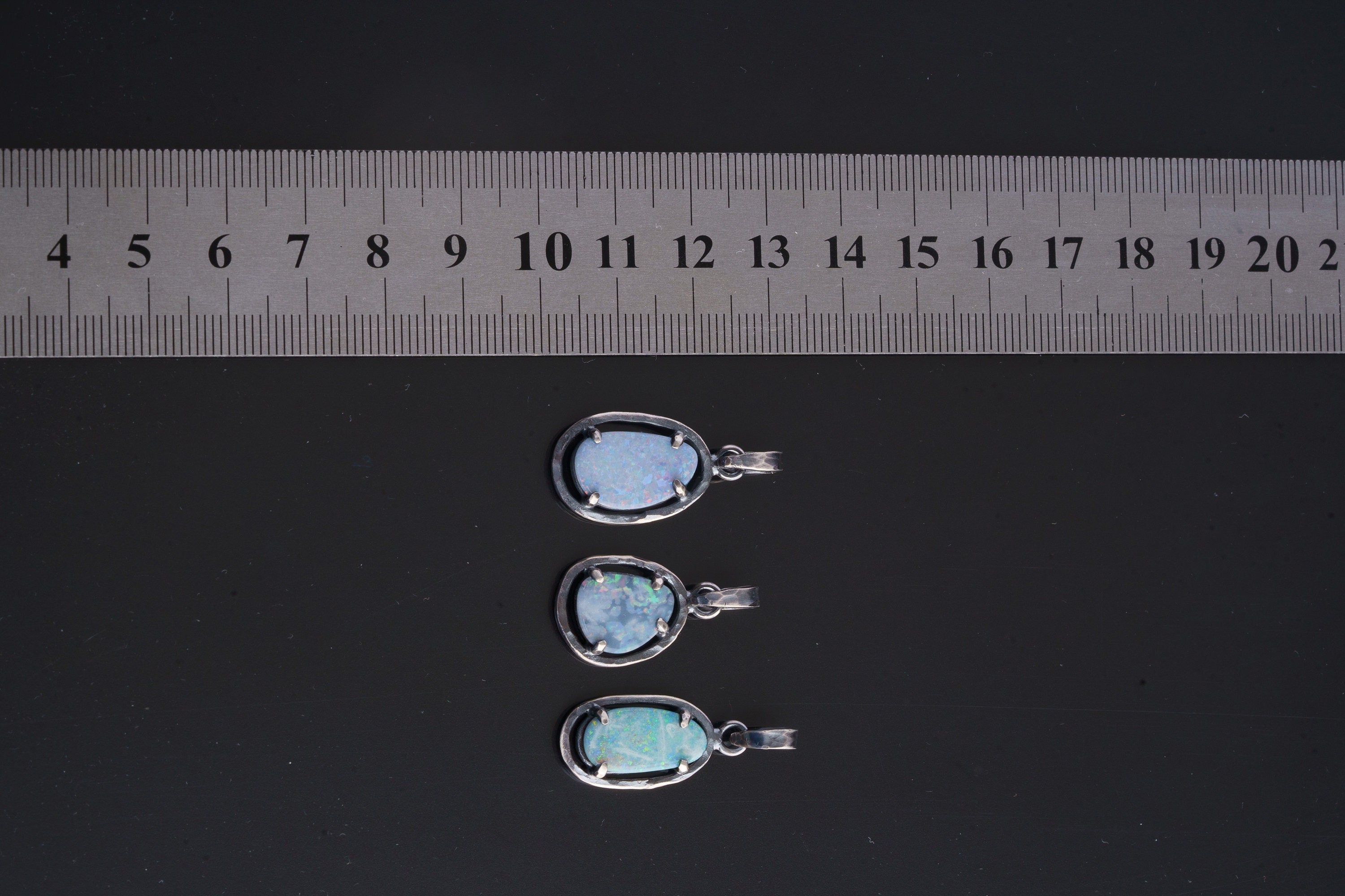 Four oval gemstone pendants in oxidized sterling silver, including Lightning Ridge Opal Doublet with bright colour play.