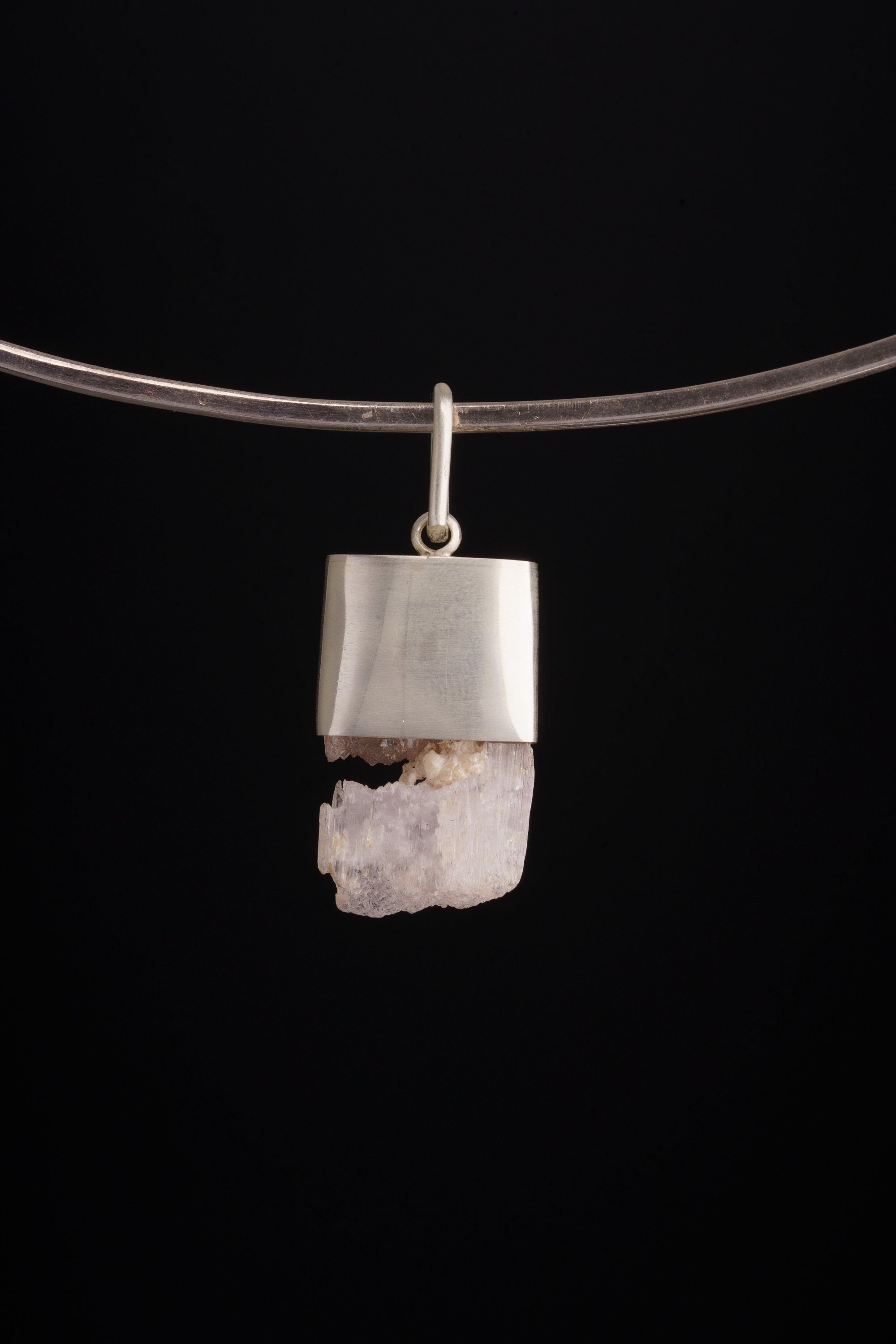 Pink Kunzite Sapphire wand pendant shown worn on a black necklace, with soft pink crystal and brushed sterling silver setting.