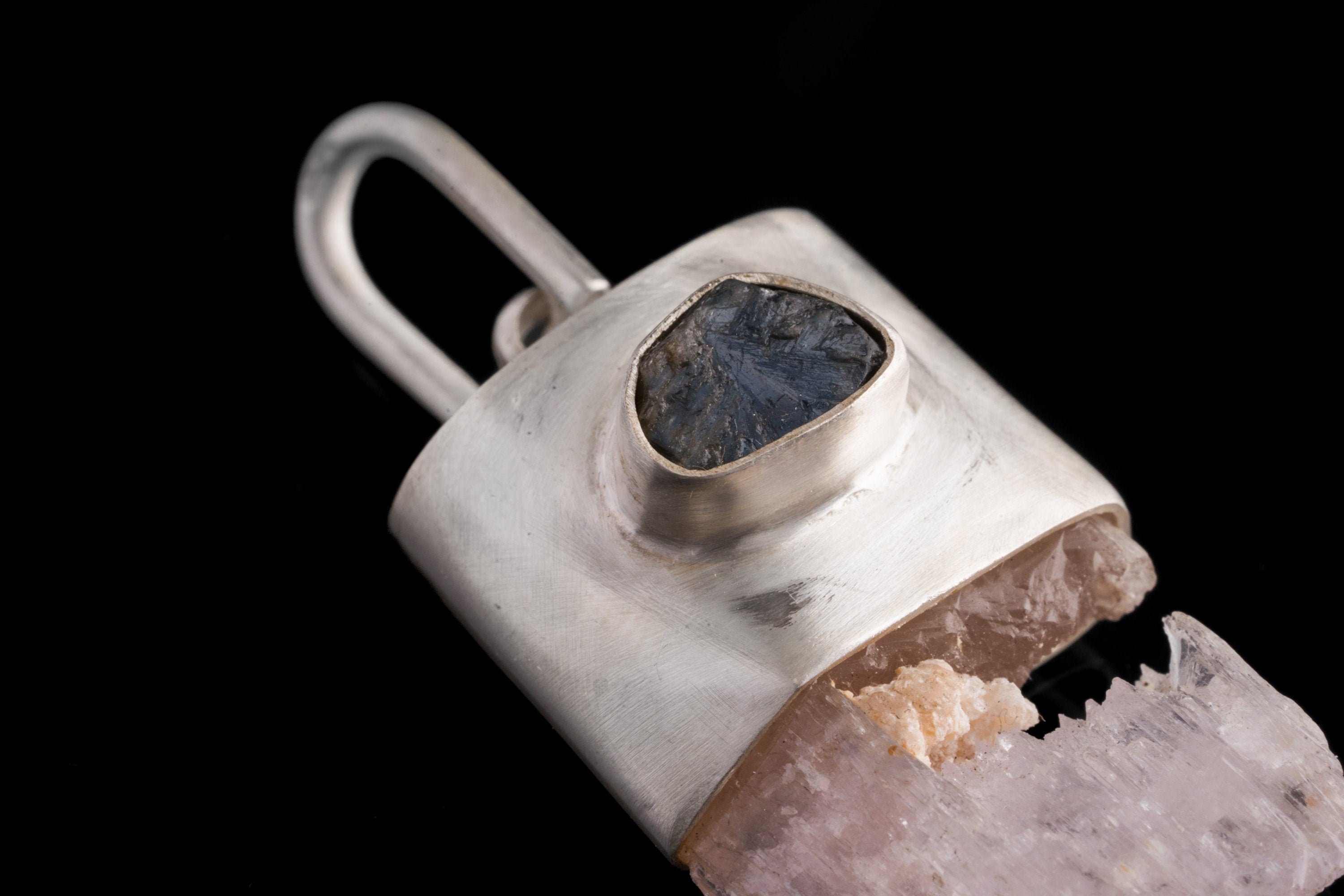 Close-up of Pink Kunzite Sapphire wand pendant showing large hinged bail, brushed silver texture, and raw crystal body.