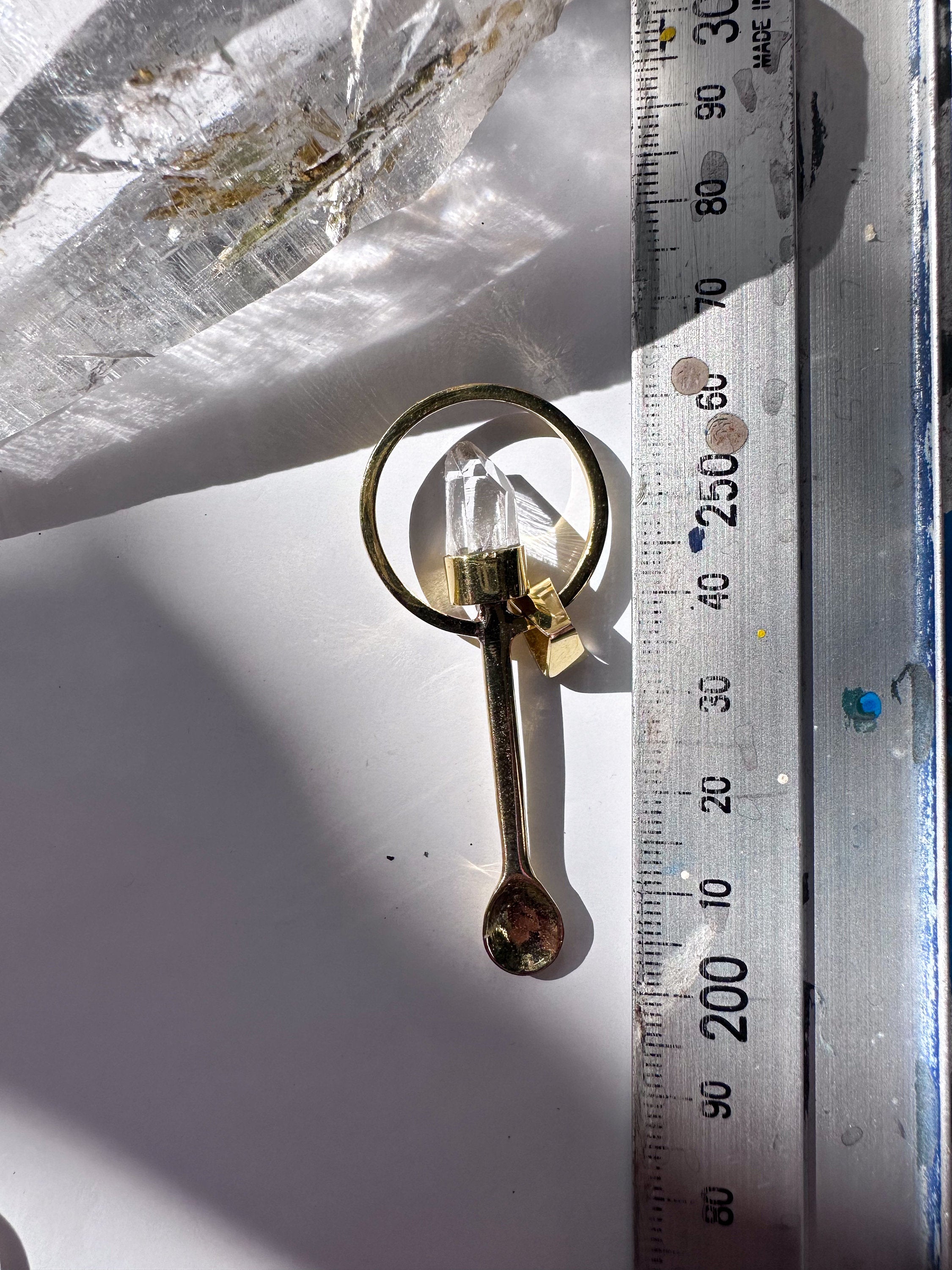 Lemurian Quartz fairy spoon pendant shown beside a ruler for scale with gold-plated brass and clear crystal point.