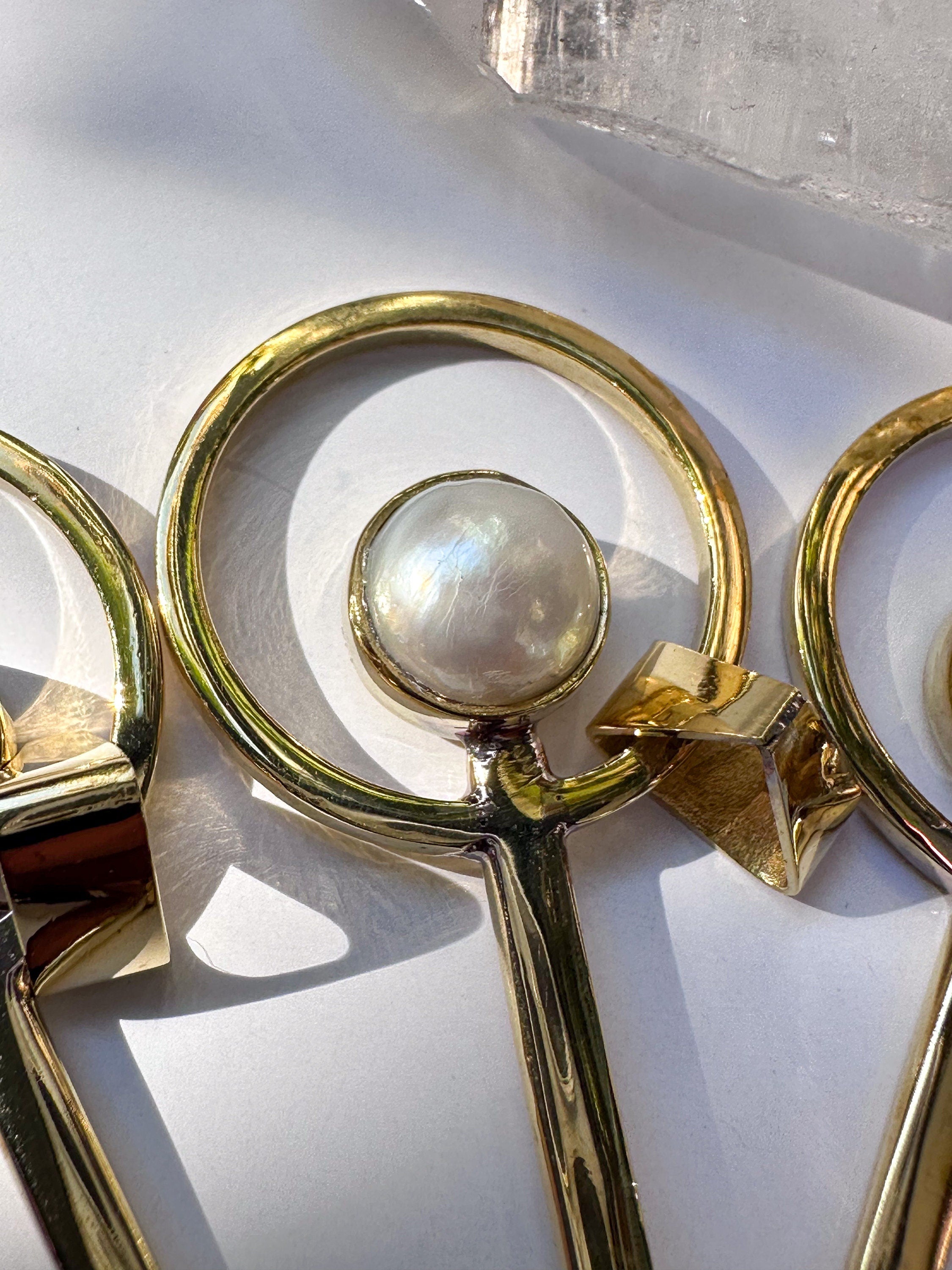 Close-up of South Sea Pearl fairy spoon collection showing 3 micron gold-plated brass and luminous Pearl settings.