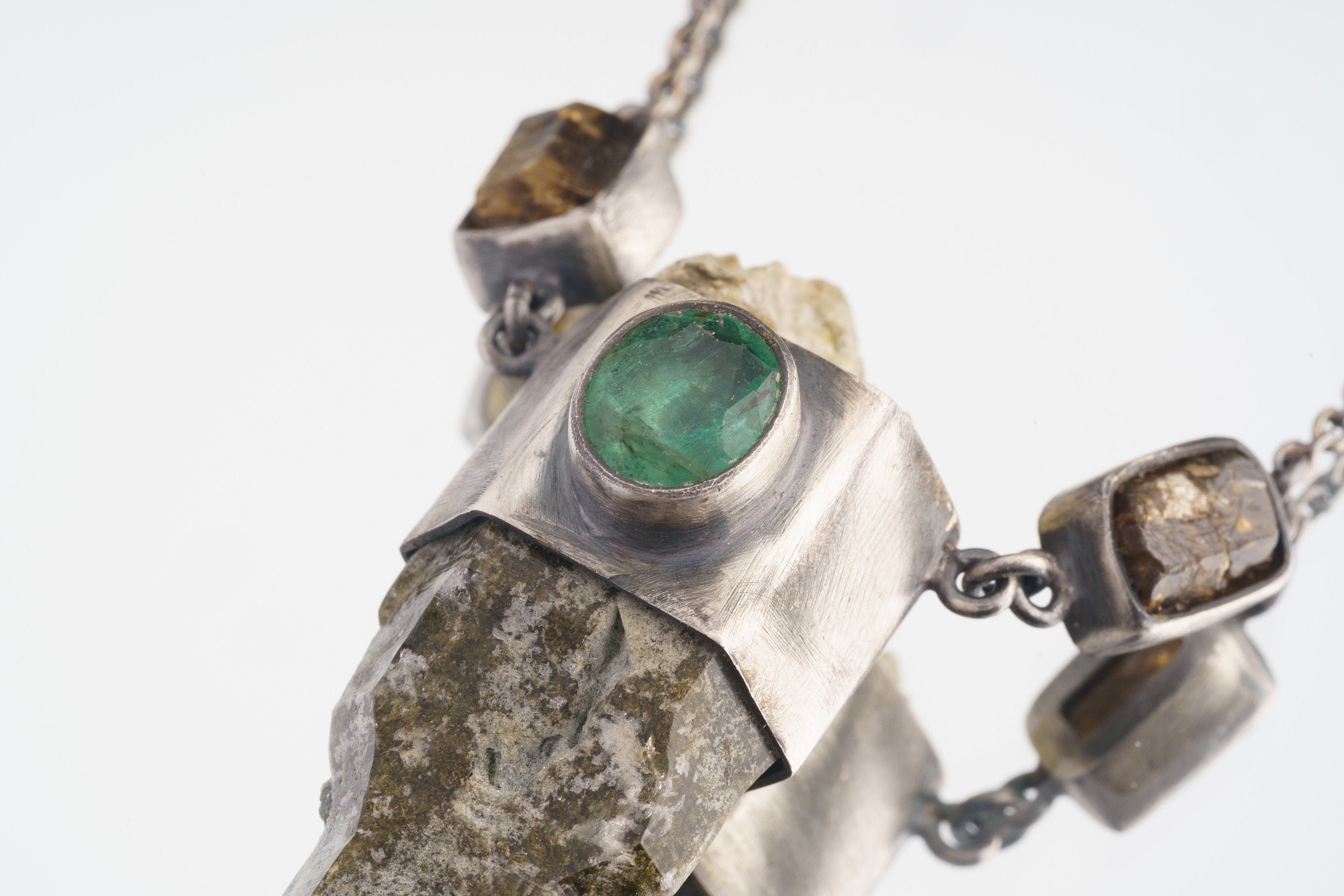 Close-up of Nepalese Emerald and Dravite Tourmaline details in an oxidized sterling silver Himalayan Quartz pendant.