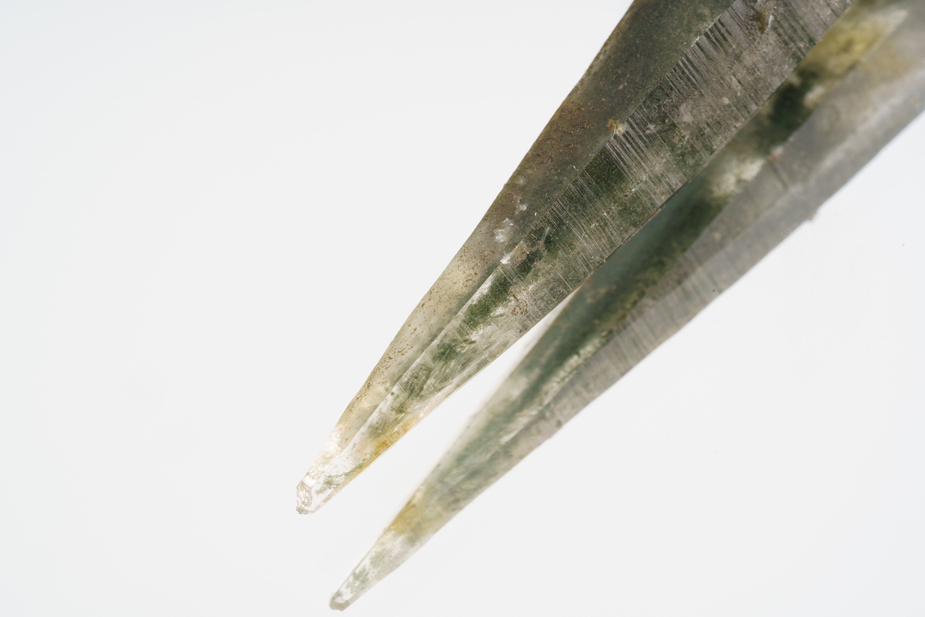 Close-up of Optical Clear Himalayan Quartz showing green chlorite inclusions, clear crystal body, and pointed termination.