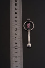 Rubellite Tourmaline sterling silver spoon pendant shown beside a ruler for scale with brushed silver body and pink-red stone.