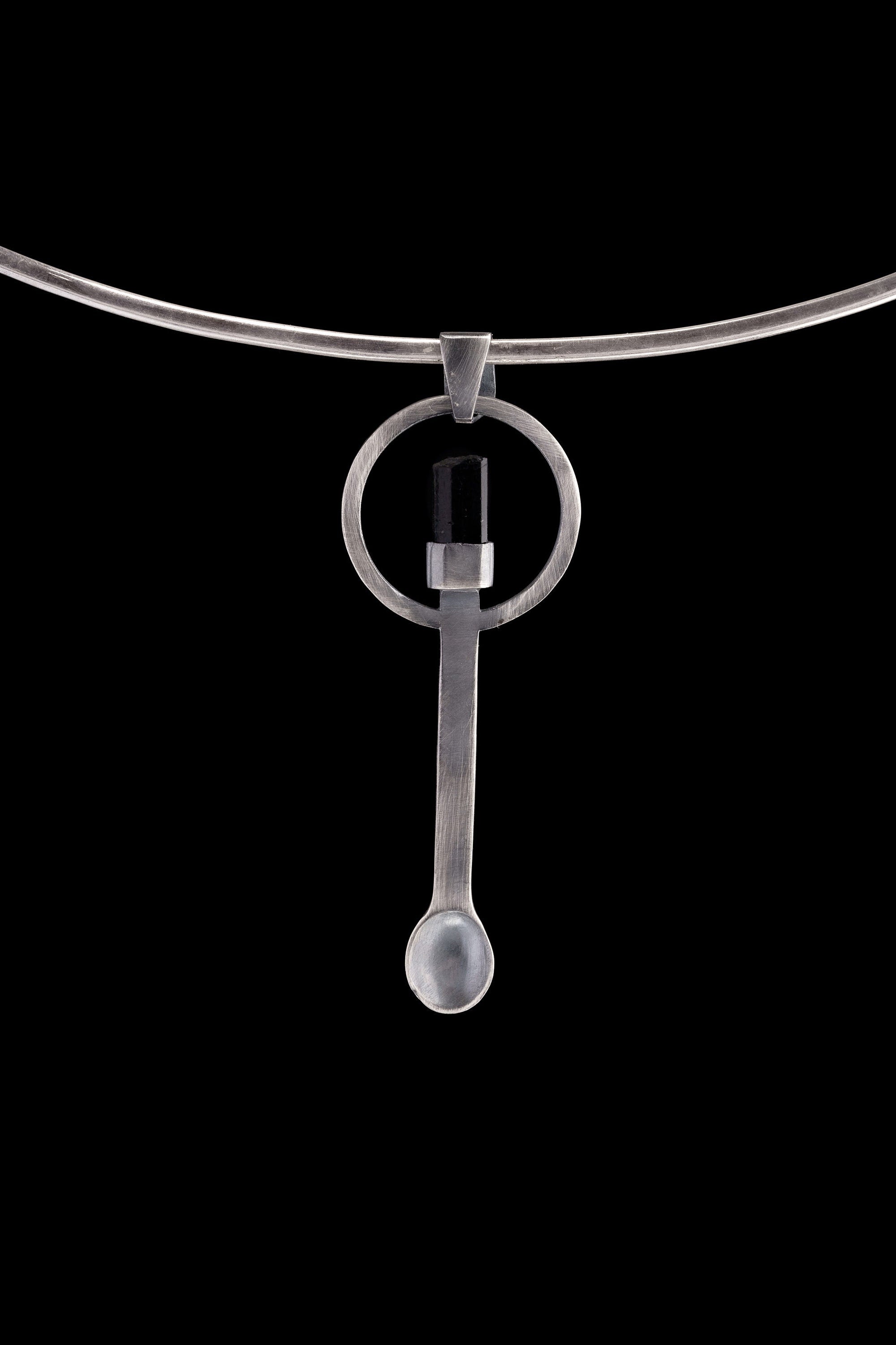 Black Tourmaline sterling silver spoon pendant shown on a choker with hammered silver and dark stone setting.