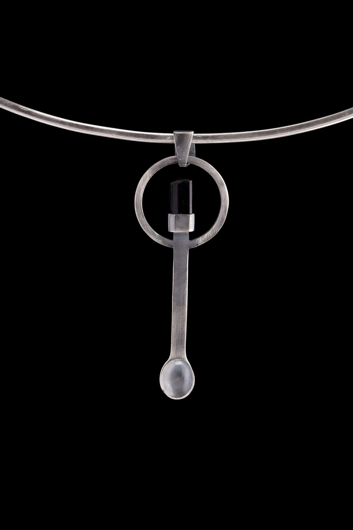 Black Tourmaline sterling silver spoon pendant shown on a choker with hammered silver and dark stone setting.