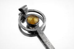 Close-up of Mexican Amber fairy spoon showing brushed sterling silver texture and warm fossil resin stone.