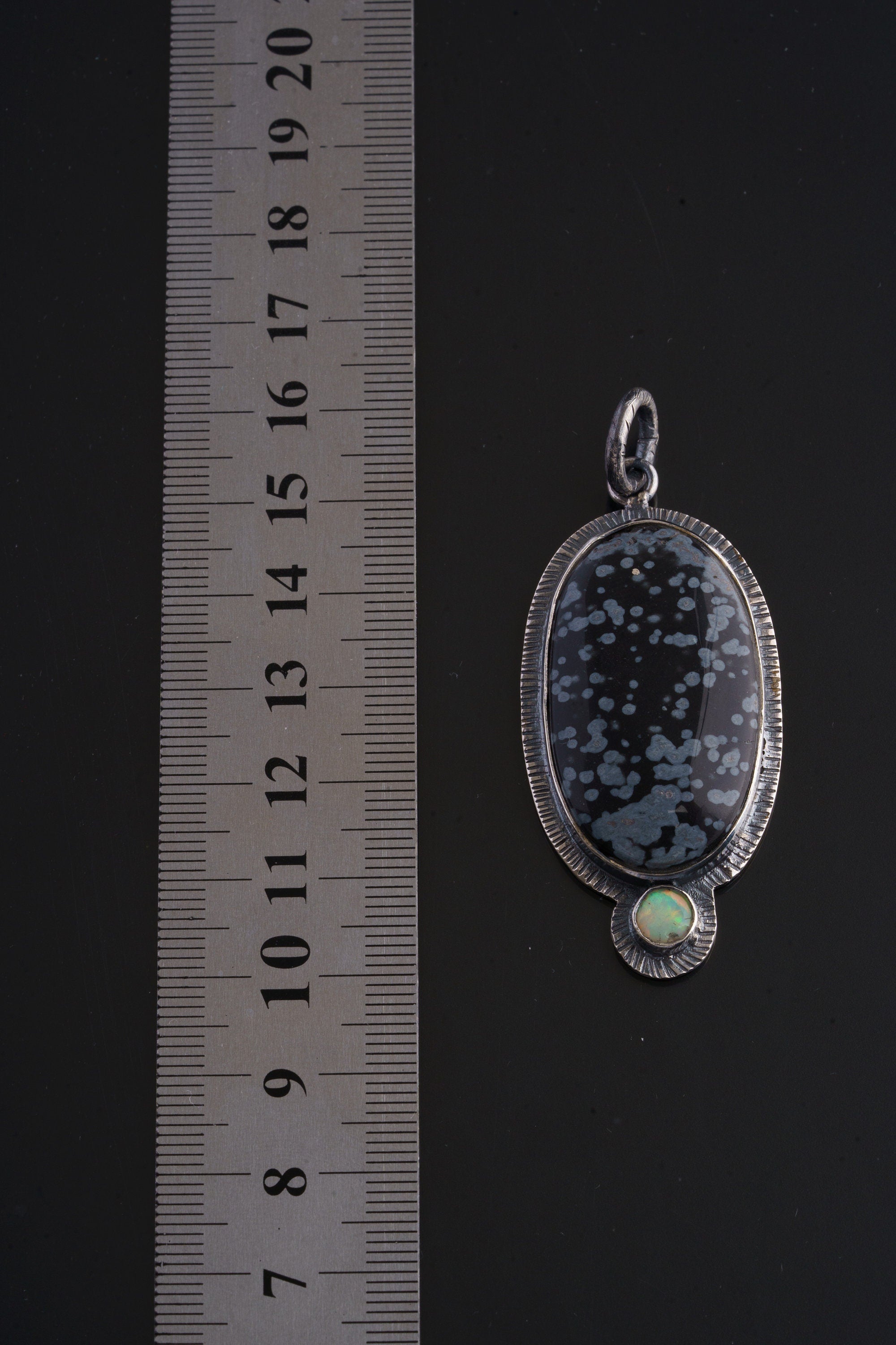Dalmatian Jasper Ethiopian Opal sterling silver pendant shown beside a ruler for scale with sun-inspired frame.