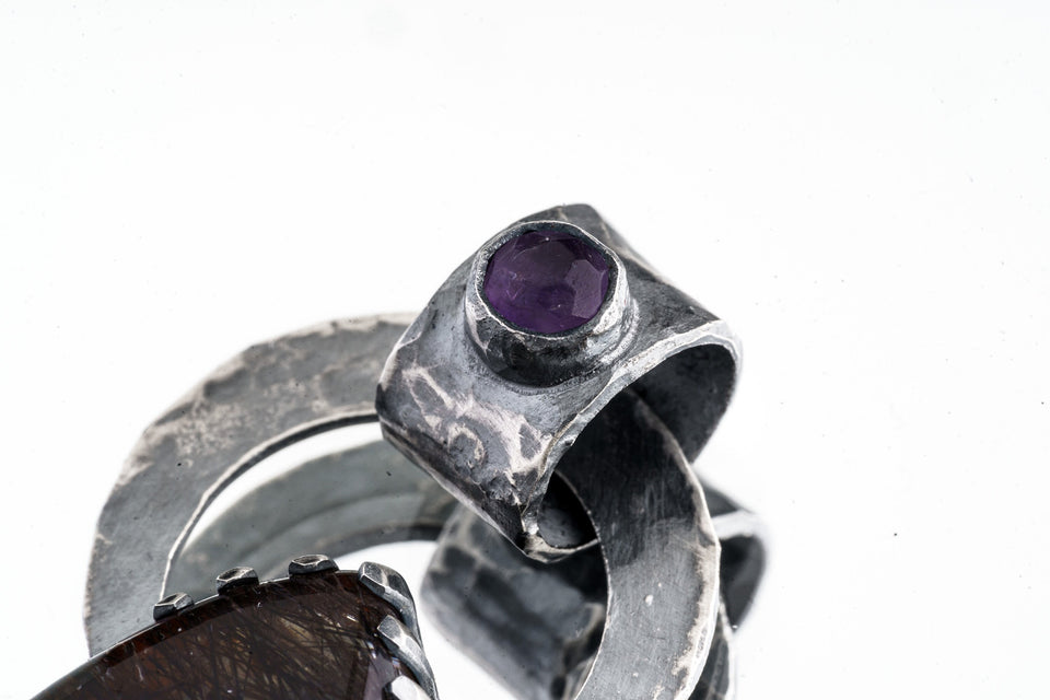 Close view of Black Rutile Quartz set onto the large bail of an Amethyst pendant.