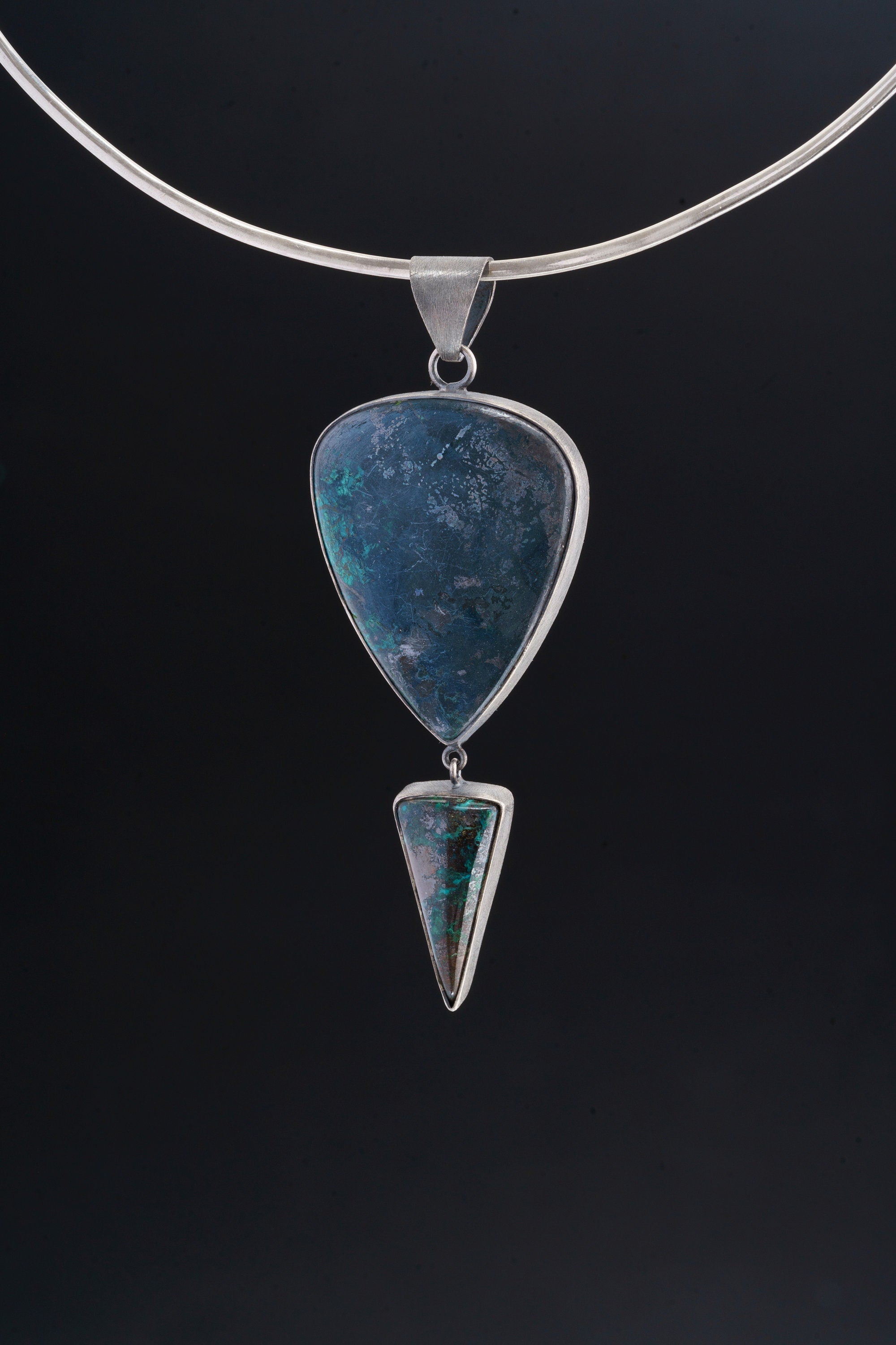 Malachite Chrysocolla statement pendant displayed on a choker against dark background with silver setting.