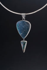 Malachite Chrysocolla statement pendant displayed on a choker against dark background with silver setting.