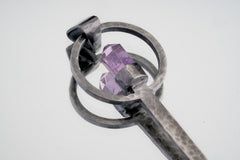 Close-up of Amethyst Generator ritual spoon showing textured sterling silver setting and cut purple crystal point.