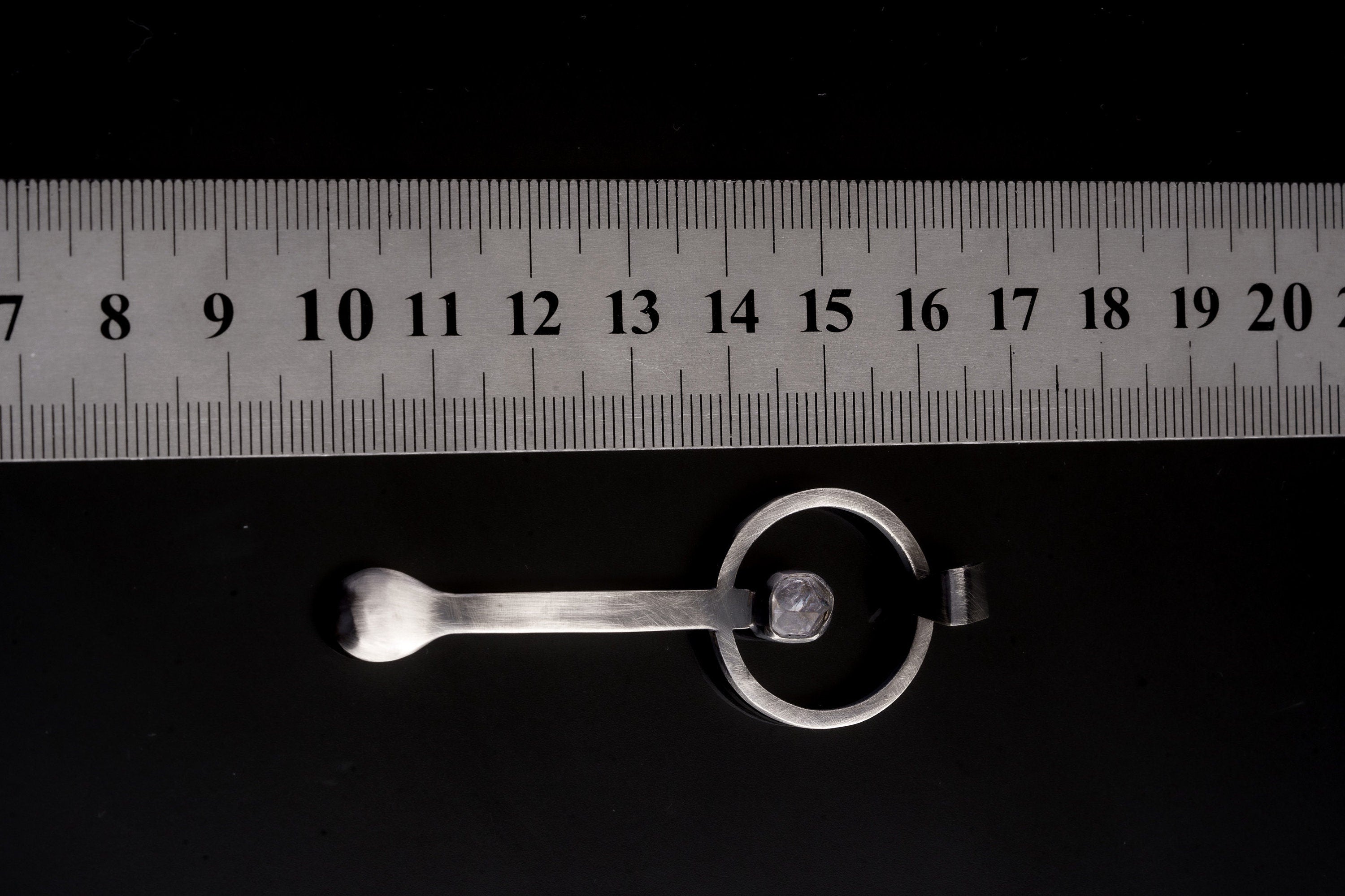 Himalayan Laser Quartz sterling silver spoon pendant shown beside a ruler for scale with solid cast silver body.