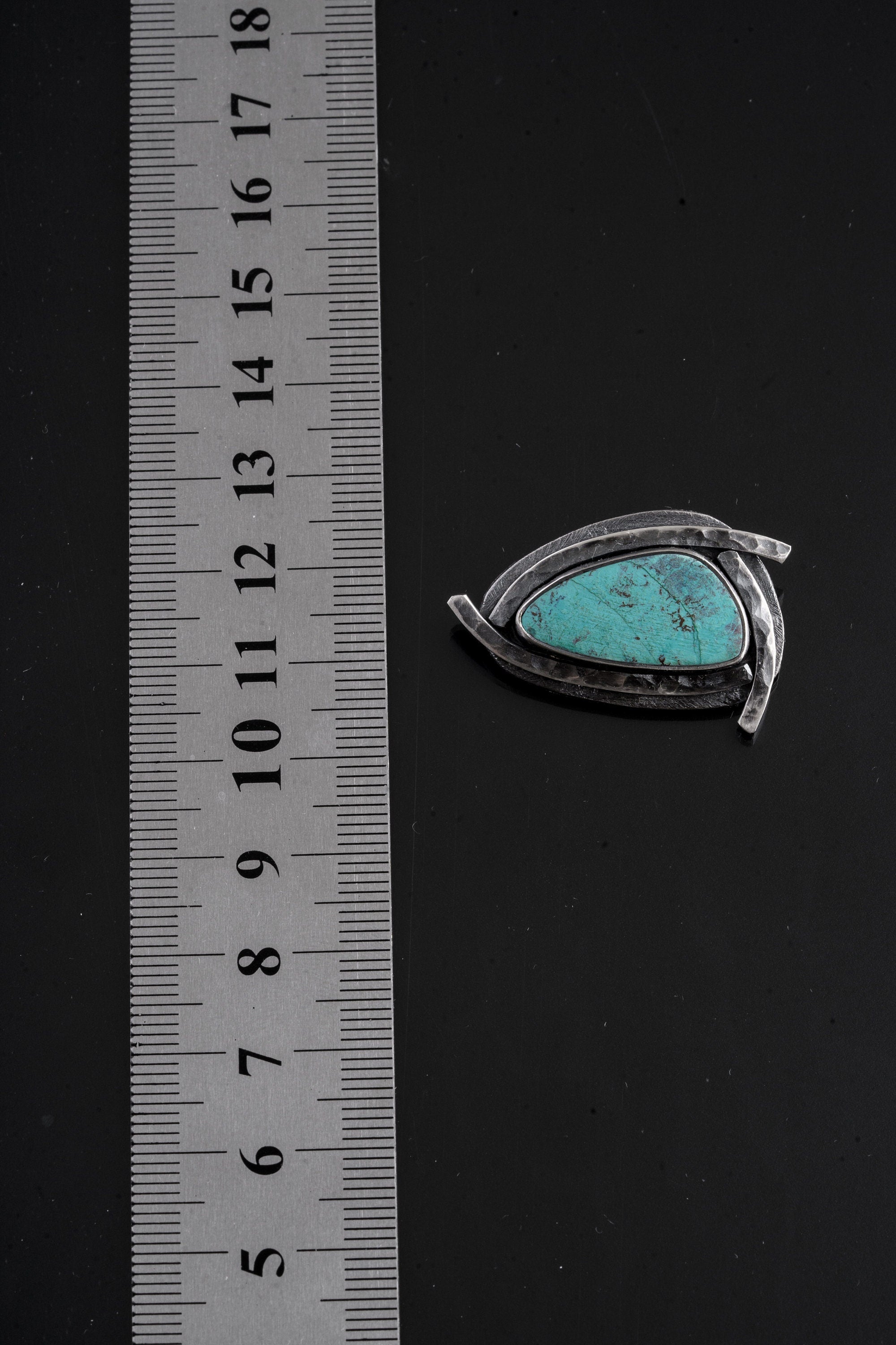 Close-up of Australian Chrysocolla pendant showing vivid blue-green stone, matrix detail, and sun-ray silver work.