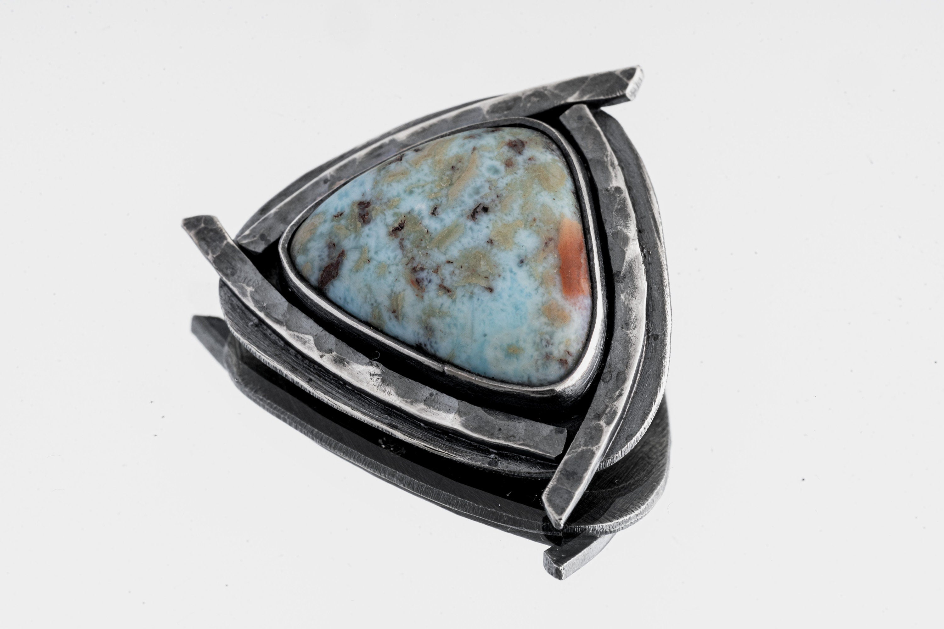 Azure Triad Larimar pendant shown on white background with blue ocean stone and oxidized silver triangle frame.