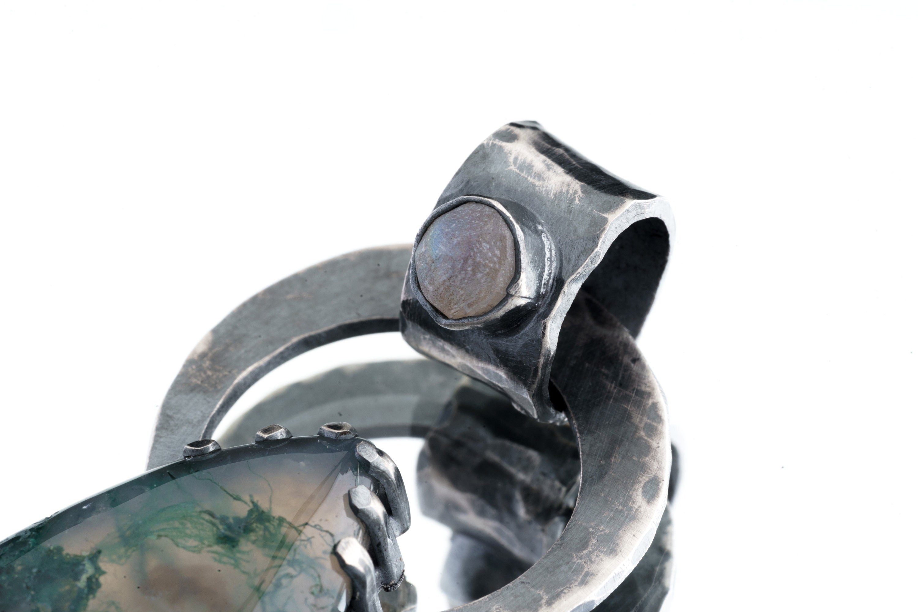 Close-up of Moss Agate set into the bail of a Blue Moonstone pendant with oxidized silver texture.
