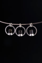 Himalayan Tourmaline halo pendant displayed on silver choker against black background.