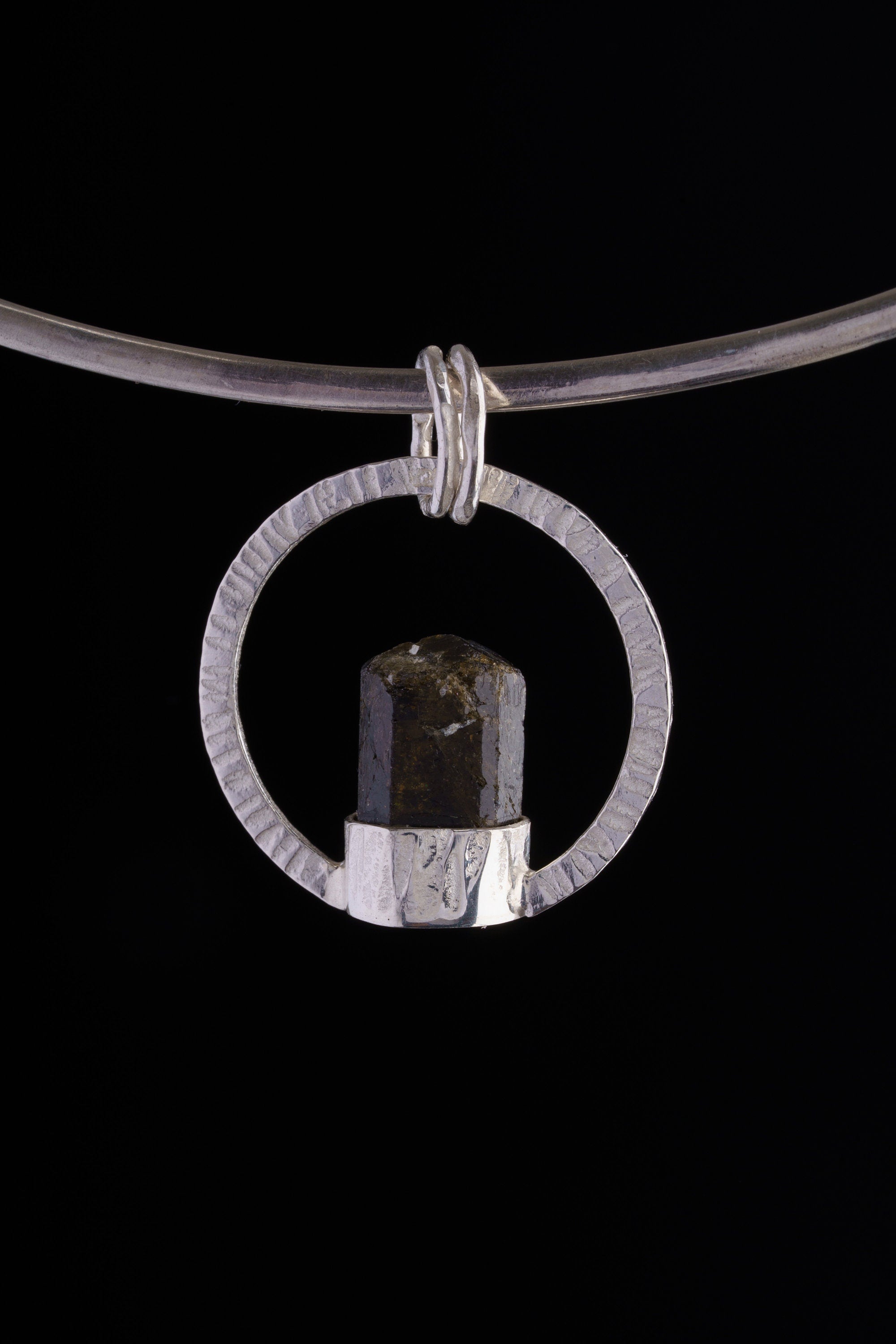 Sterling silver circular halo pendant with Dravite Tourmaline set point-up inside.