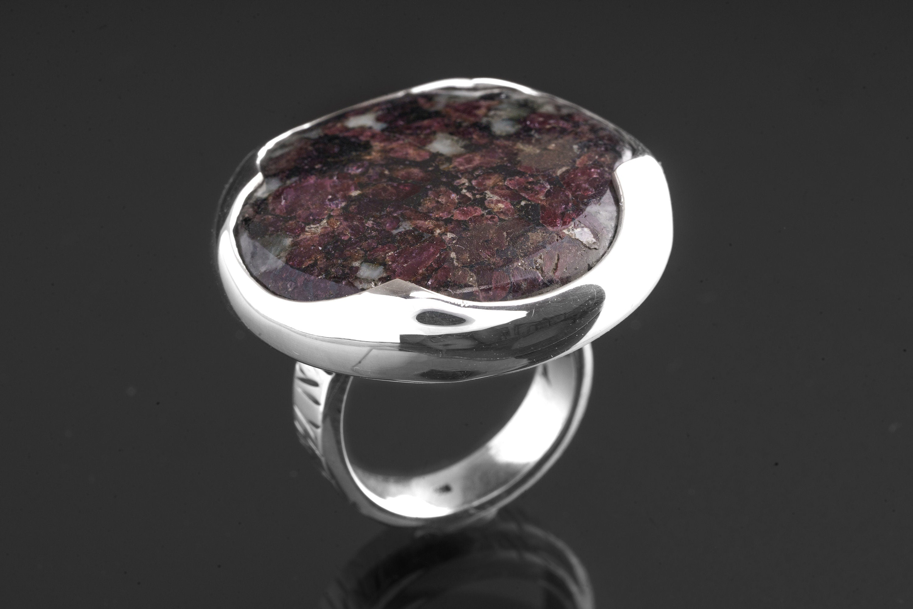 Side view of Ruby in Mica and Quartz Matrix ring showing waved bezel, textured sterling silver band, and raised setting.