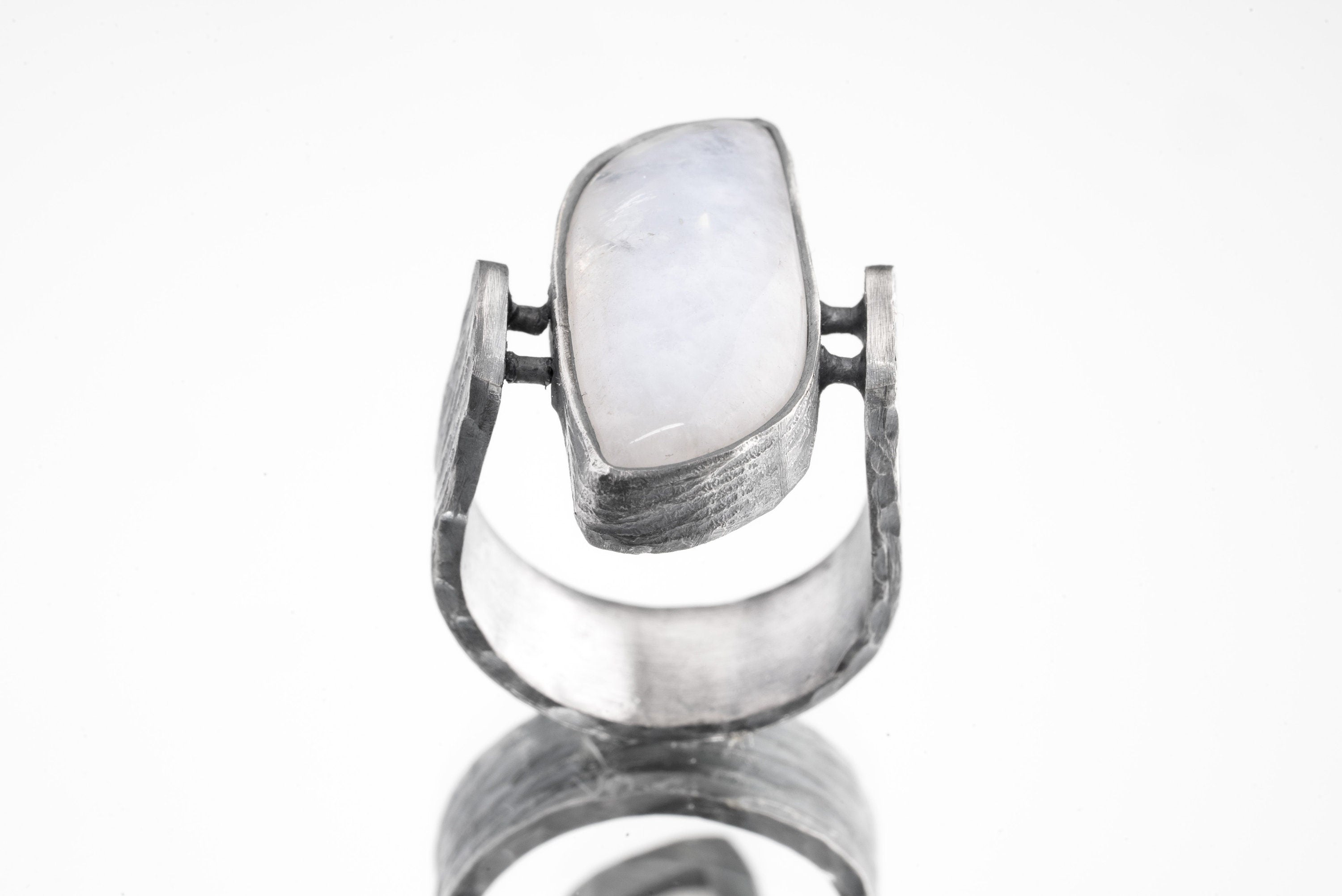 Front view of rectangular Moonstone ring showing U-shaped oxidized silver band and sculptural lunar setting.