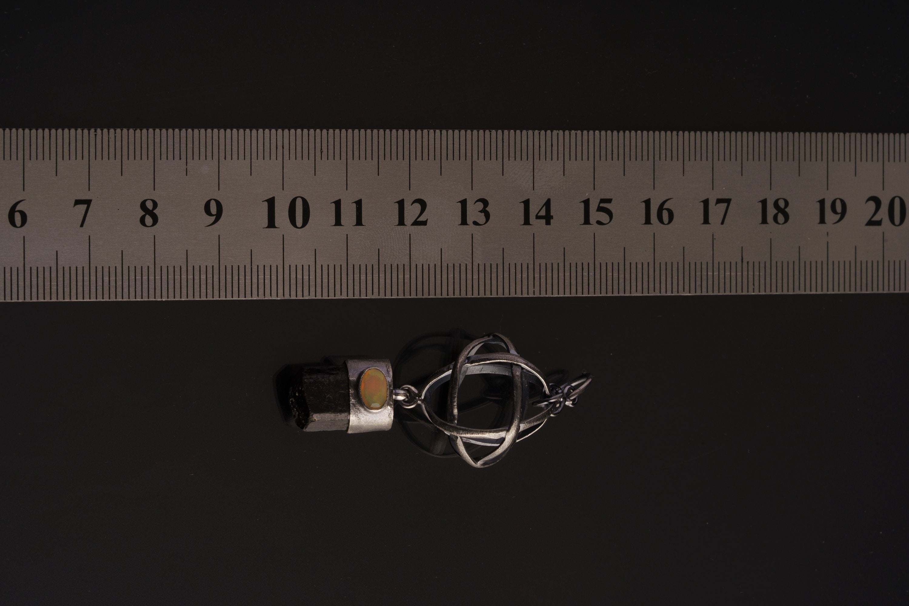 Himalayan Brown Tourmaline Ethiopian Opal sphere pendant shown beside a ruler for scale, measuring approximately 5.5 to 6 cm long.
