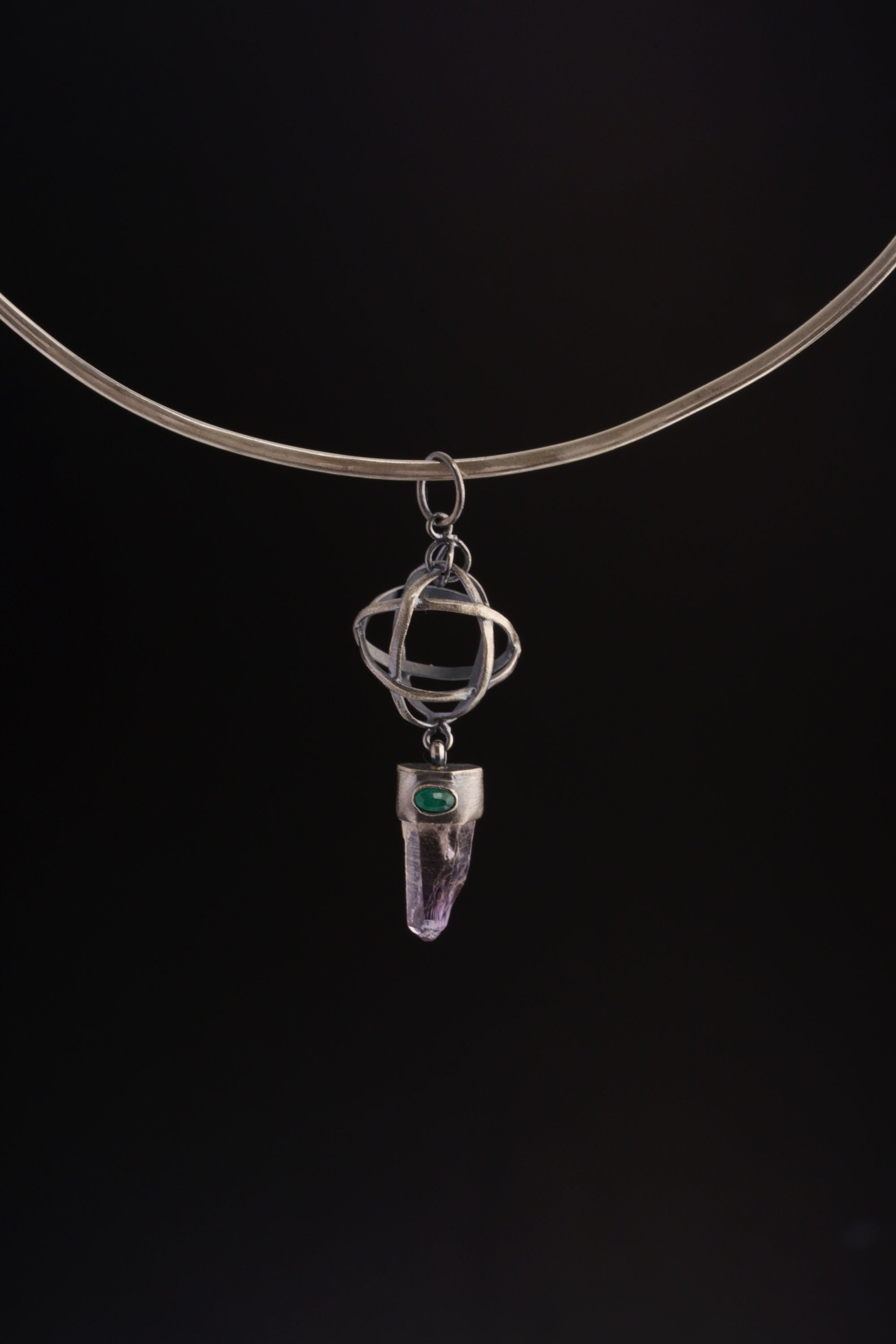 Vera Cruz Amethyst Emerald sphere pendant shown on a black cord, with oxidized sterling silver and sculptural wire sphere.