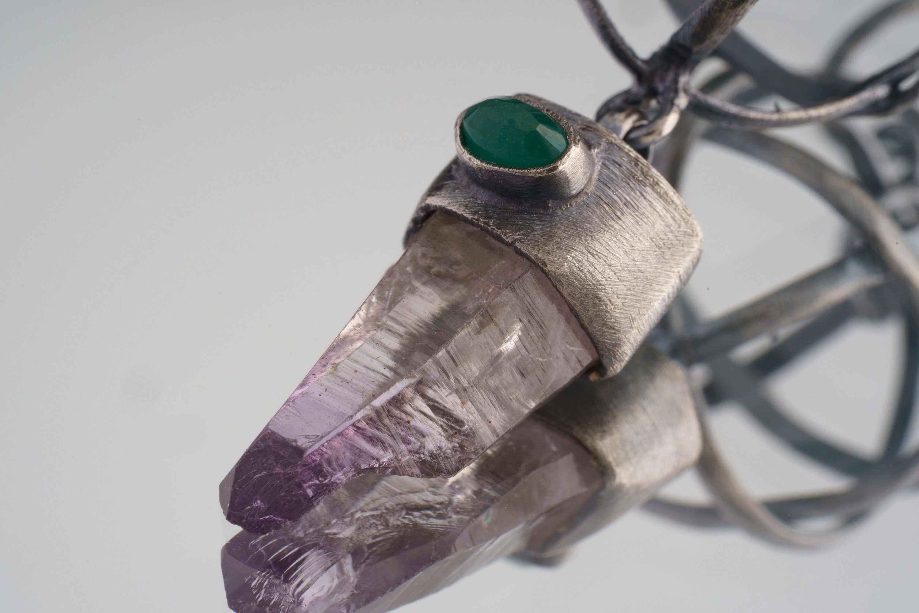 Close-up of Vera Cruz Amethyst point with eye-shaped Emerald set into an oxidized sterling silver cap.