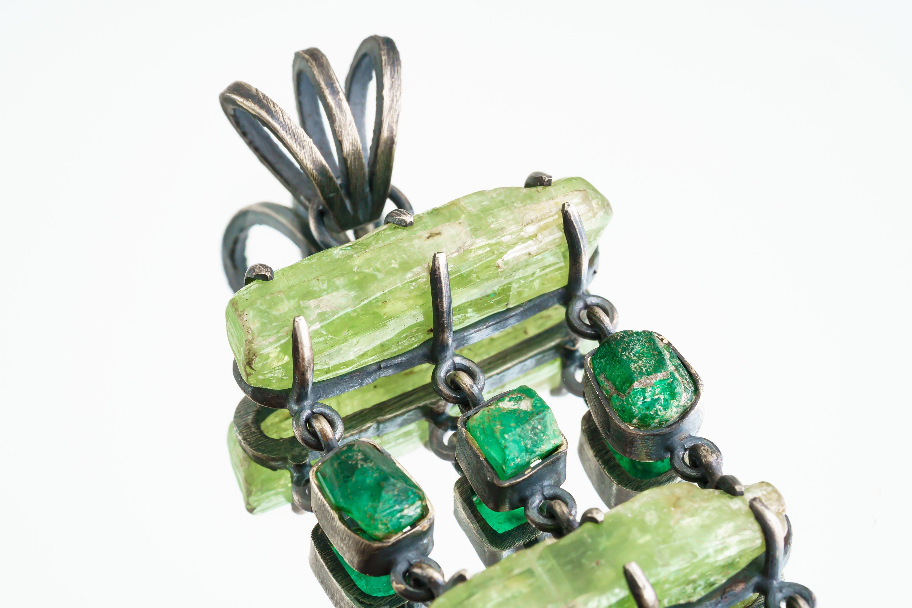 Close-up of raw Green Kyanite, Australian Emeralds, and oxidized sterling silver claw and bezel settings.