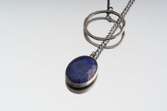 Faceted Lapis Lazuli necklace on white background with open-back sterling silver bezel and adjustable lariat chain.