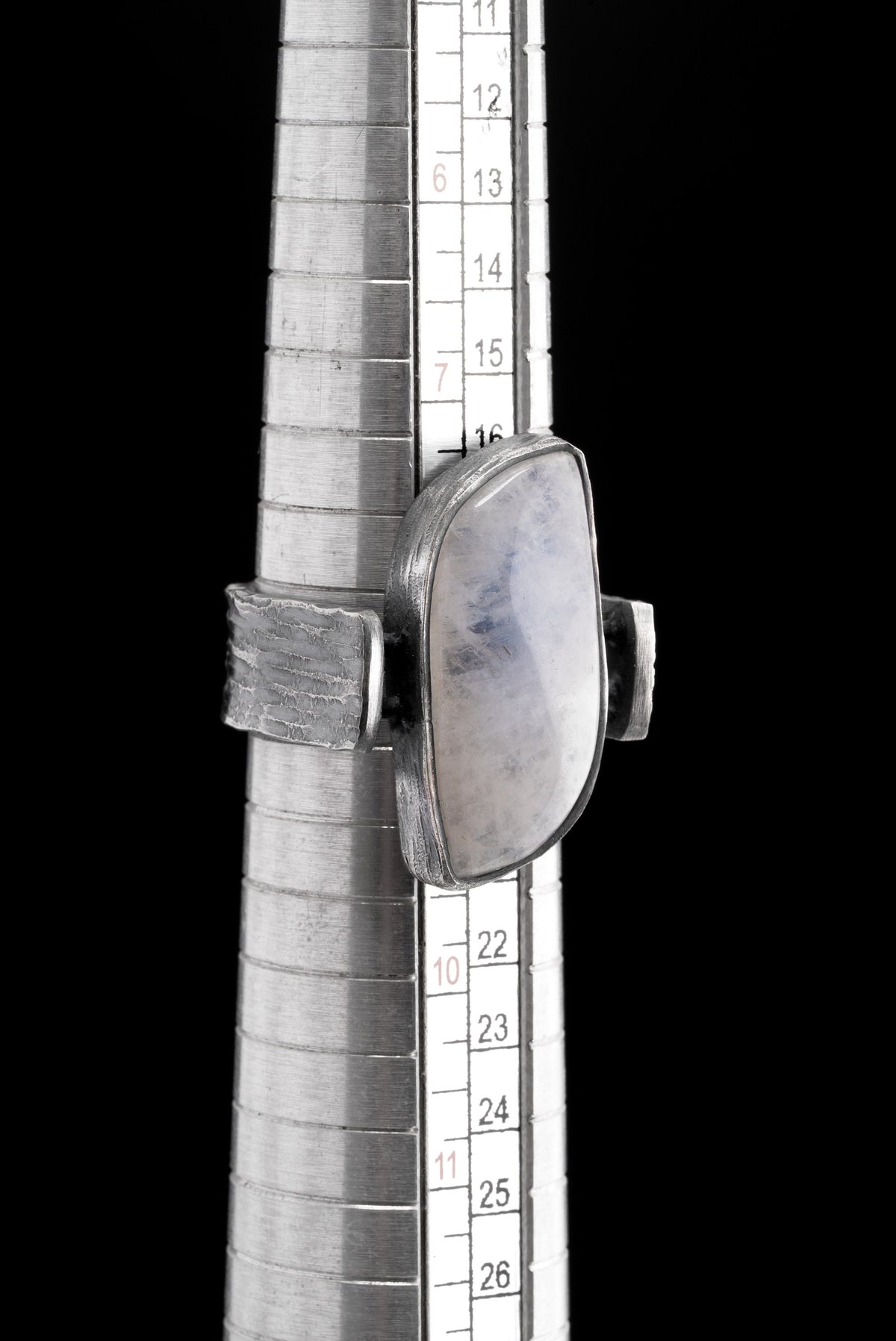 Rectangular Moonstone ring shown beside a ruler for scale, with oxidized 925 sterling silver and brutalist band profile.
