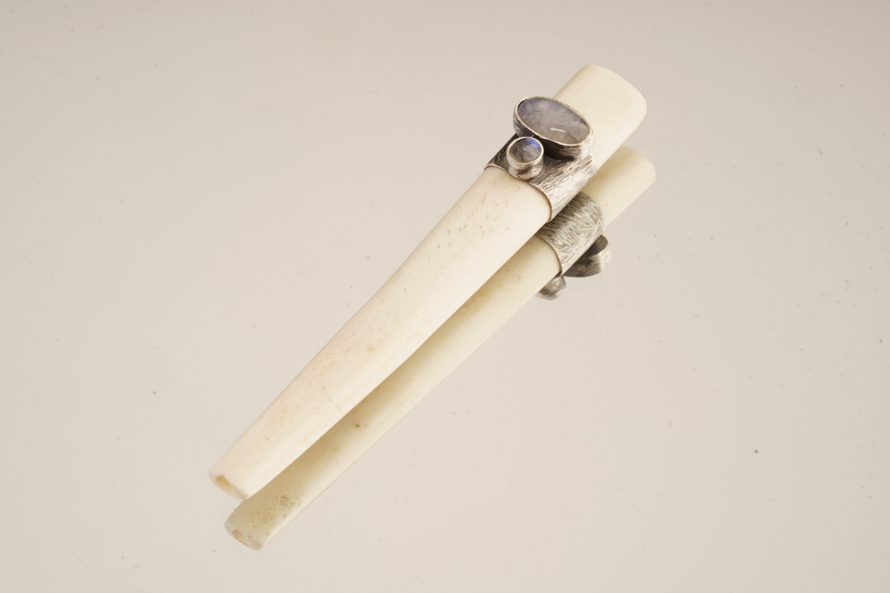 Blue Moonstone Antique Bone Tube Pendant shown on a light background with polished sterling silver band and two stones.