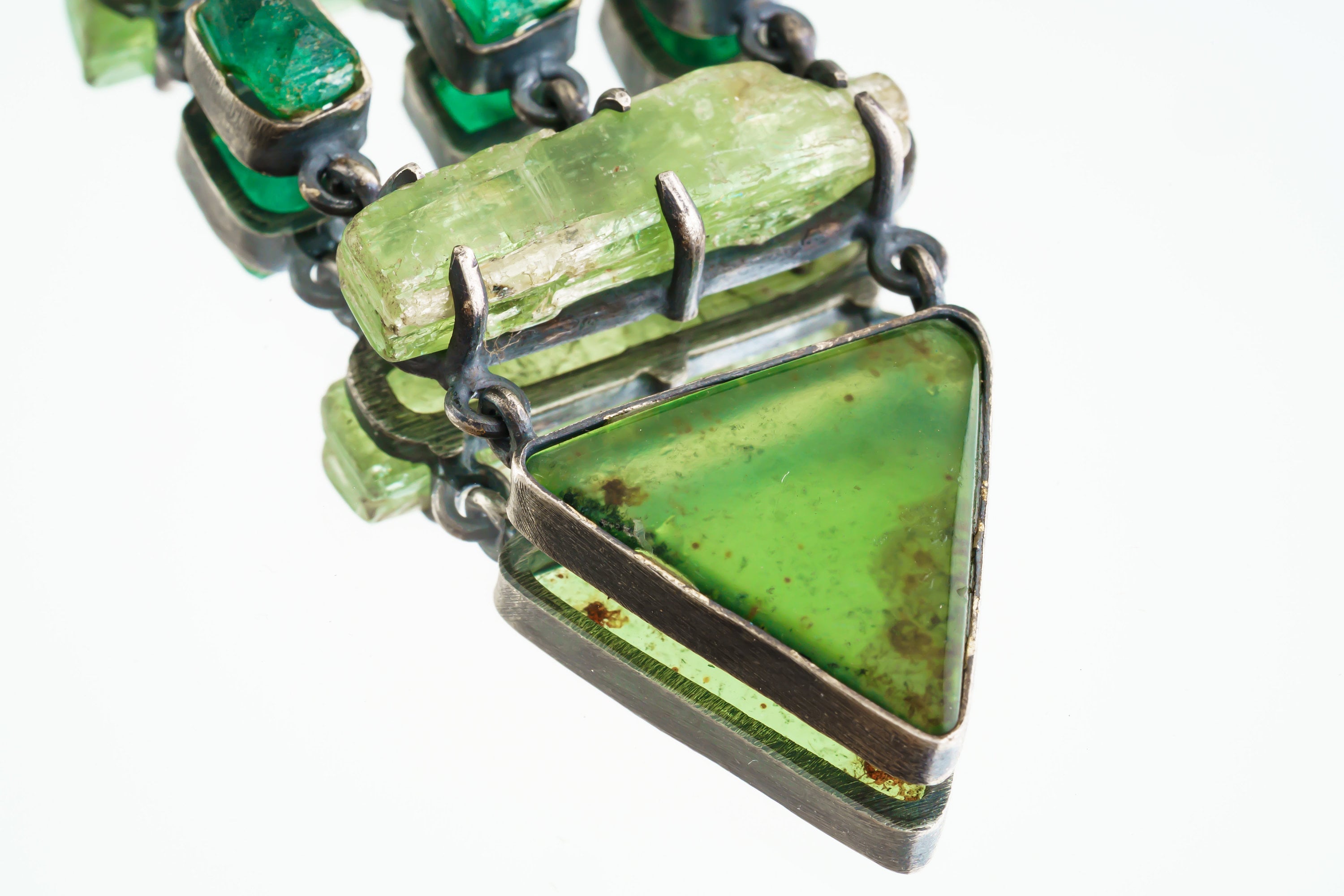 Close-up of triangular Australian Chrysoprase slice suspended below Emeralds in an oxidized sterling silver pendant.