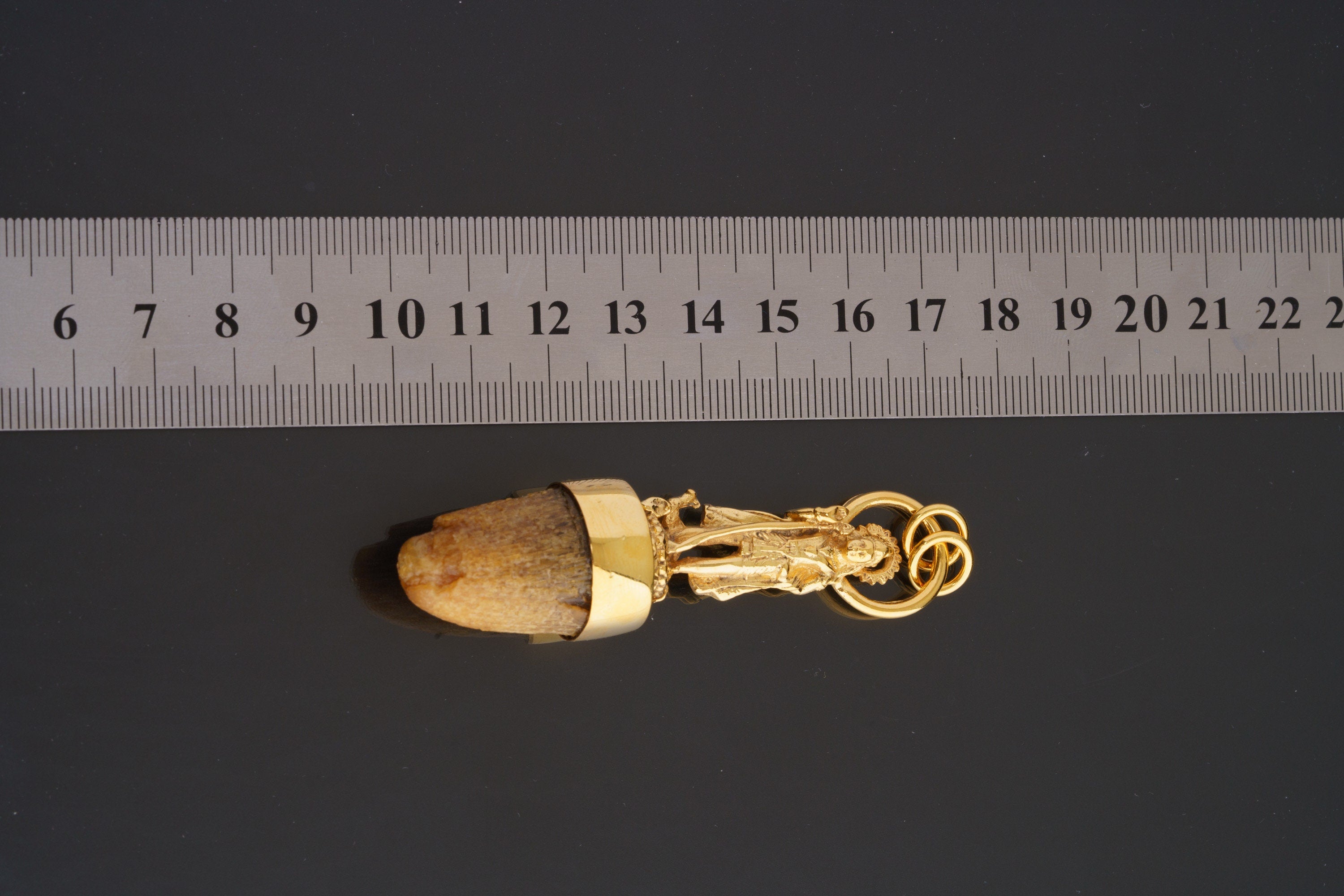 Shiva cow horn talisman pendant shown beside a ruler for scale with 24k gold-plated finish.