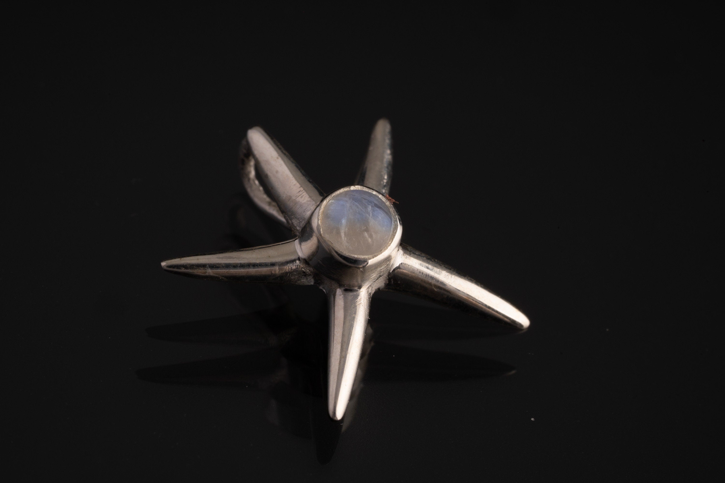 Blue Moonstone starfish charm shown on black cord, with polished 925 sterling silver and small ocean-inspired shape.
