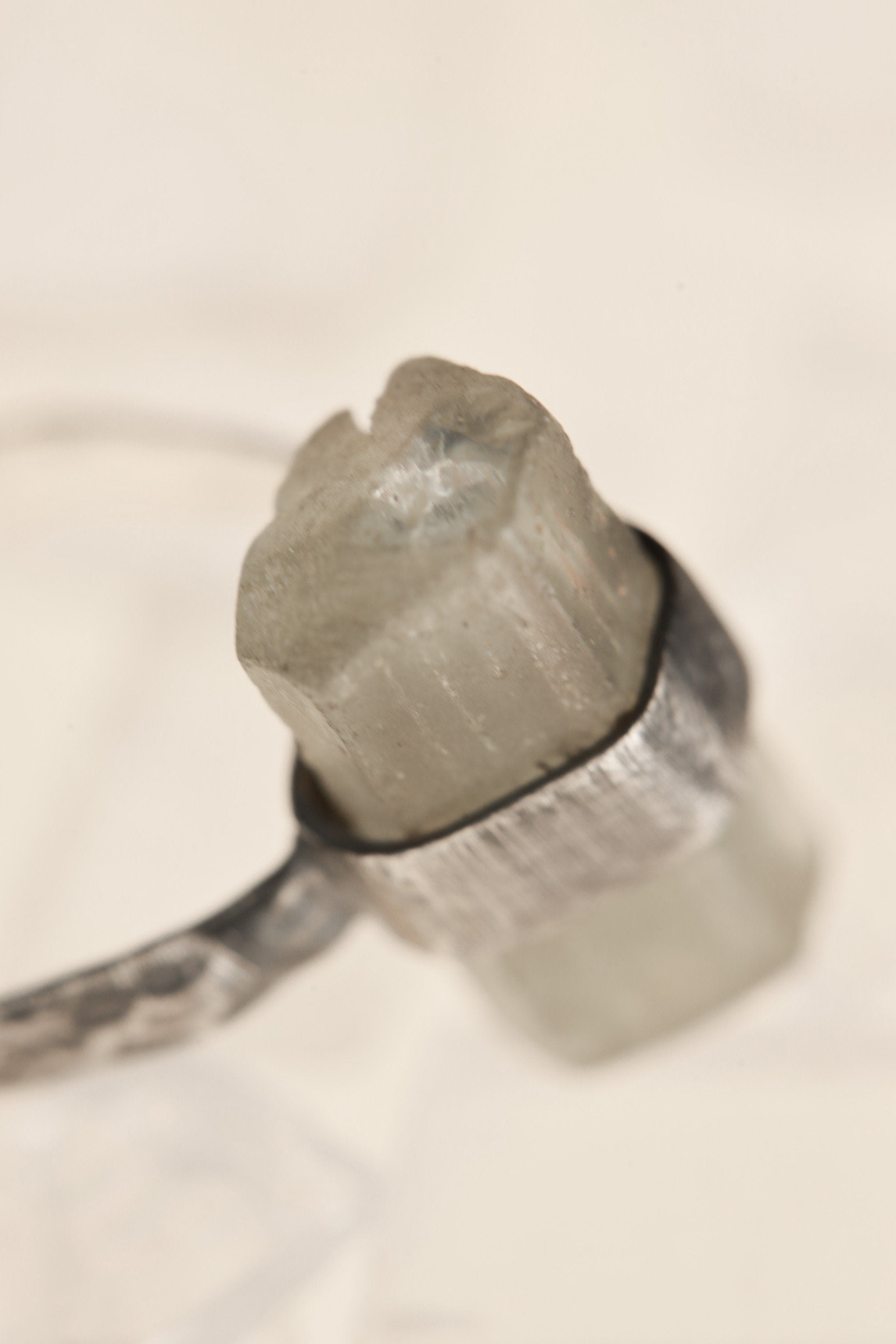 Close-up of raw Australian Aquamarine crystal in an oxidized sterling silver wrap setting with natural surface markings.