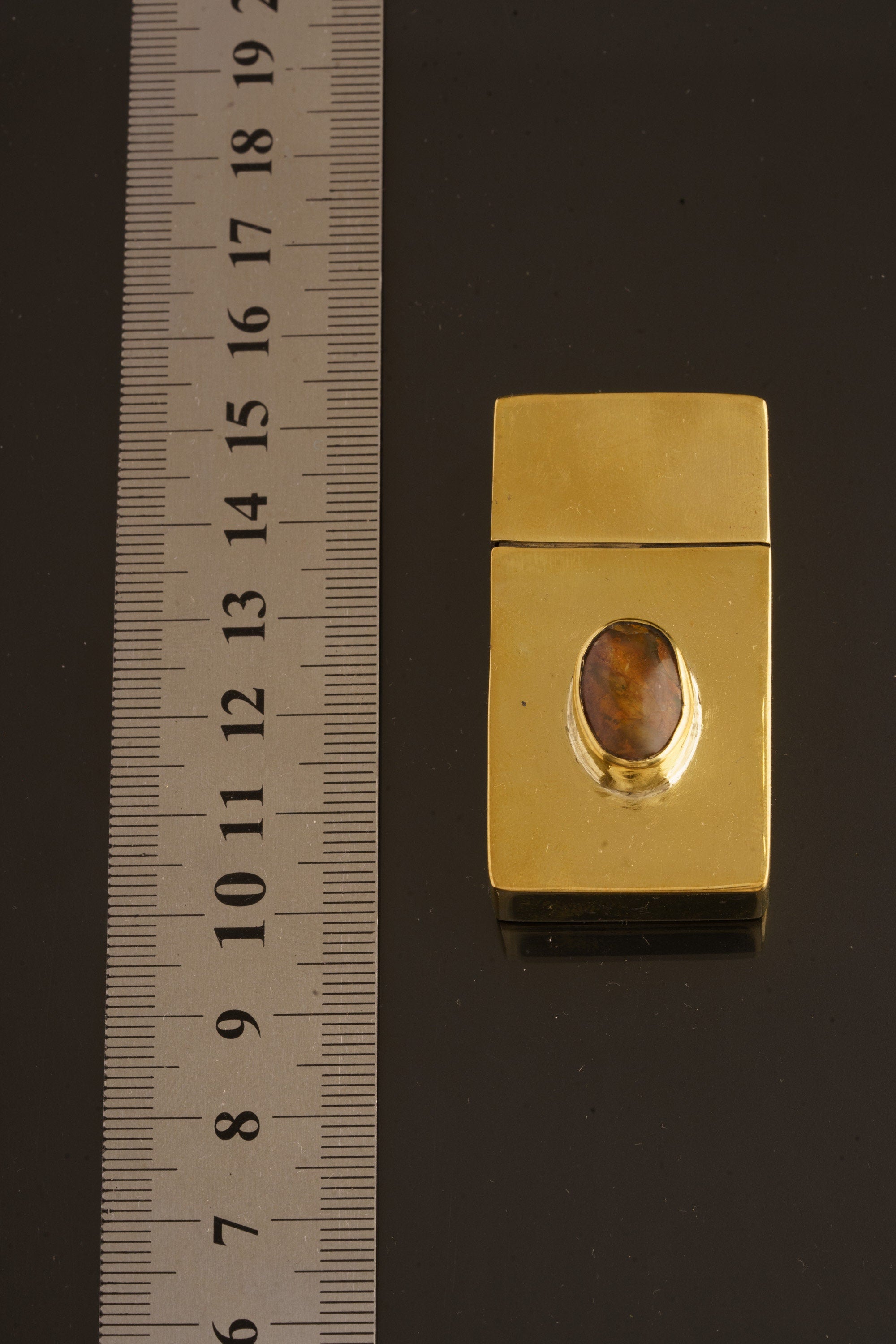 Ethiopian Opal brass matchbox shown beside a ruler for scale, with compact 2.5 x 5 x 1 cm form.