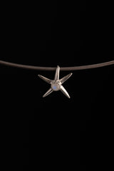 Close-up of polished sterling silver starfish charm with natural Blue Moonstone set at the centre.